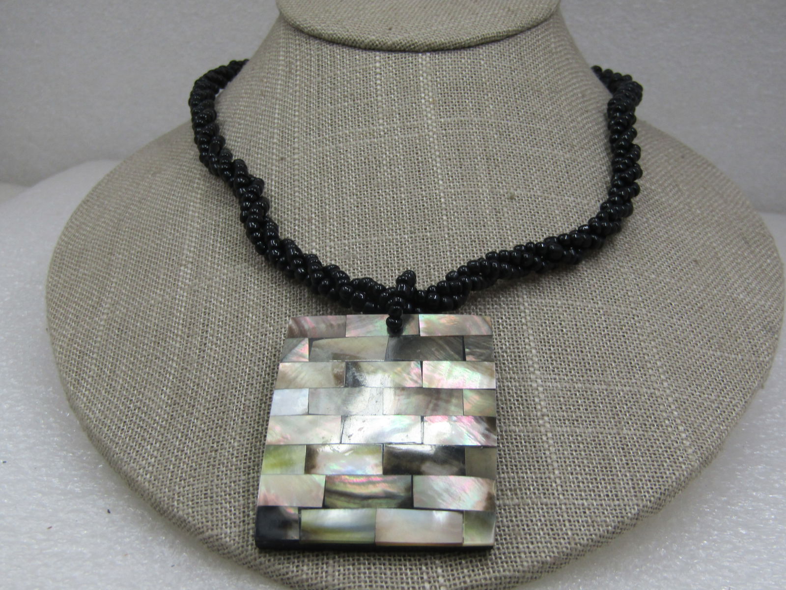 Vintage Southwestern Black Seed Beaded Ablone Necklace, 18": Vintage Southwestern Black Seed Beaded Ablone Necklace, 18". This has a rectangular tiled abalone pendant that is 1-7/8" long nad 1.5" wide with double beaded bail. The chain is twisted three strands
