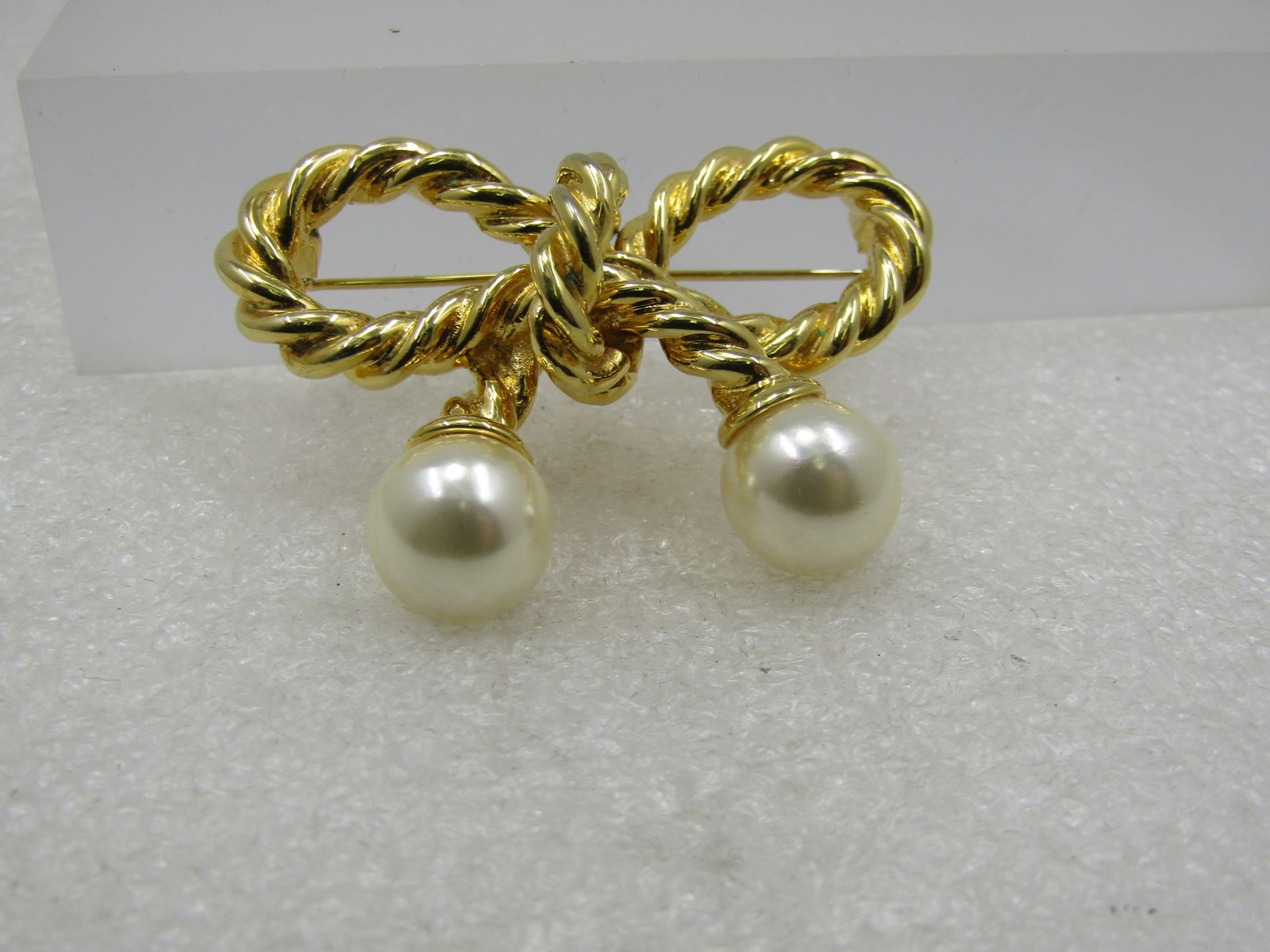 Vintage Rope Bow & Faux Pearl Brooch, 1980's-1990's, 2": Title: Vintage Rope Bow & Faux Pearl Brooch, 1980's-1990's, 2" Description: Vintage Rope Bow & Faux Pearl Brooch, 1980's-1990's, 2" by 1.5" tall. It has a white lustered faux pearl at the tips of the 