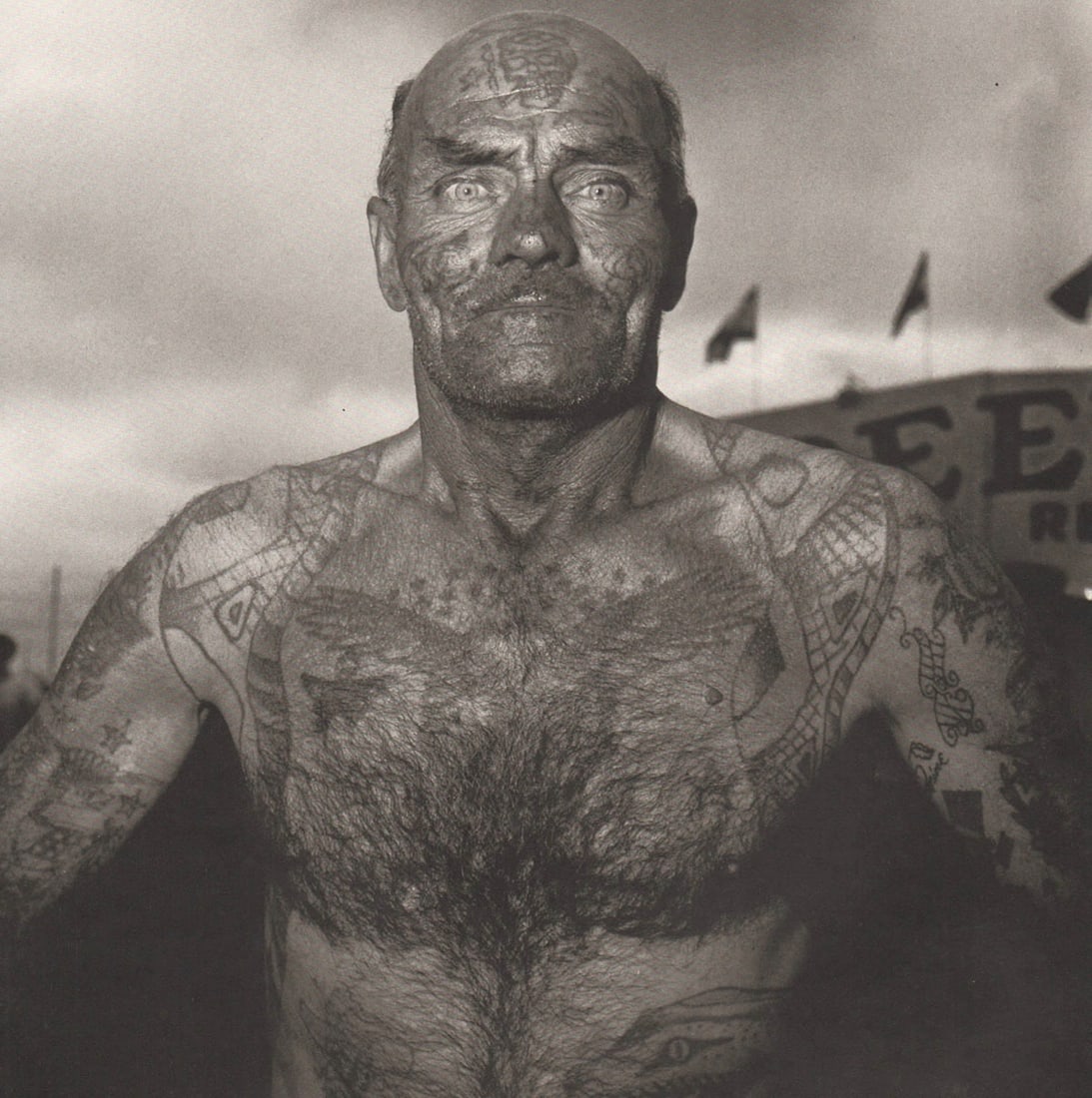 DIANE ARBUS - Tattooed Man at a Carnival, MD, 1970: Title: DIANE ARBUS - Tattooed Man at a Carnival, MD, 1970 Description: Artist: DIANE ARBUS Print Title: Tattooed Man at a Carnival, MD, 1970 Medium: Duotone Print Printed 2000’s in Germany Image
