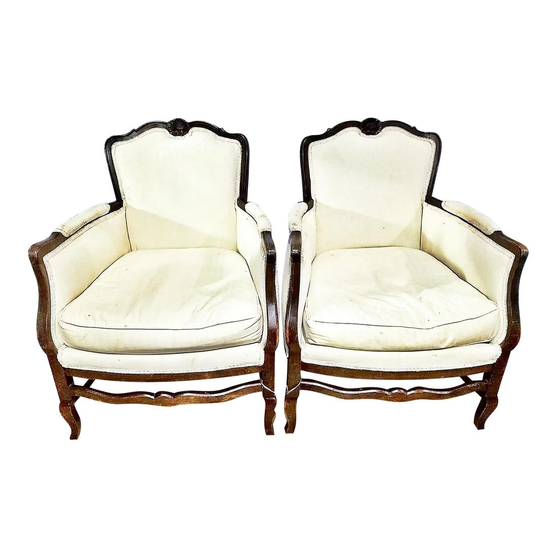Antique French Country Bergere Club Chairs- a Pair: Classic styled 19-20c Louis XV influenced, salon sized French bergere armchairs with shell carving, full cabriole leg spreaders in a newer white muslin fabric and feather seat cushion. Fabric is an un