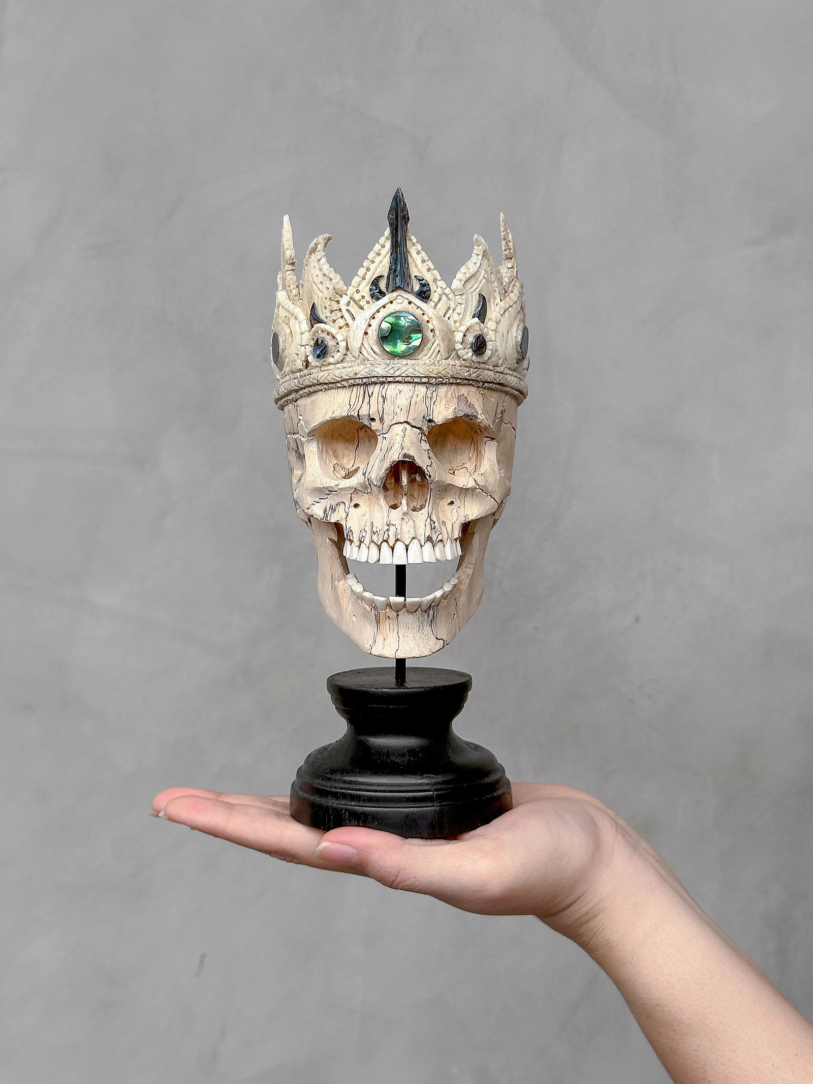 A Stunning Tamarind Human Skull with a crown and abalone details: Title: A Stunning Tamarind Human Skull with a crown and abalone details Maker:Unknown Origin: Indonesia Date/Period:2025 Materials:Tamarind Wood, Abalone, steel, wood Dimensions:Height including stand