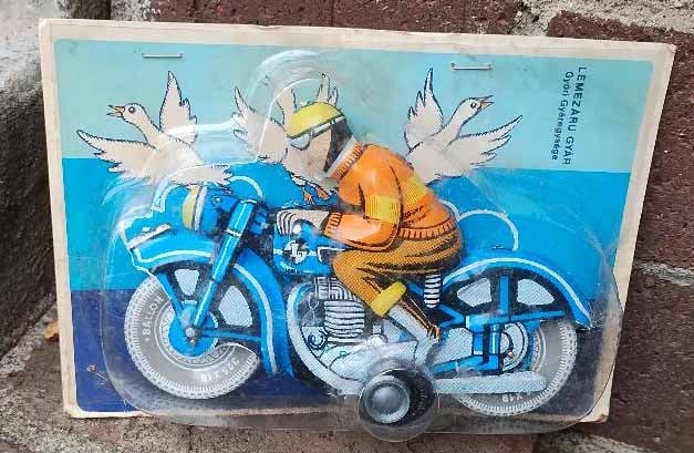 Toy motorcycle with a rider, manufactured by Lemezáru Gyár in Hungary.The toy is also: Title: Toy motorcycle with a rider, manufactured by Lemezáru Gyár in Hungary.The toy is also known as a "Ballon Cordatic" tin motorcycle.This is a friction-drive tin toy.It was produced in t