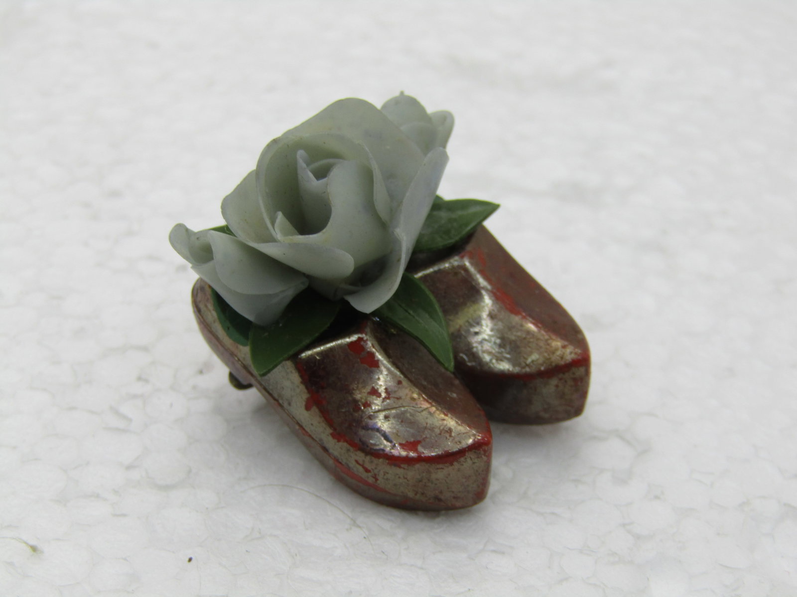 Vintage Iridescent Dutch Shoes Floral Brooch, C Clasp: Vintage Iridescent Dutch Shoes Floral Brooch, C Clasp with blue silk flower. 1.25" long, 1" wide. Likely souvenir brooch from the mid-century. Brown/orange iridescent finish on the shoes, plastic. Goo