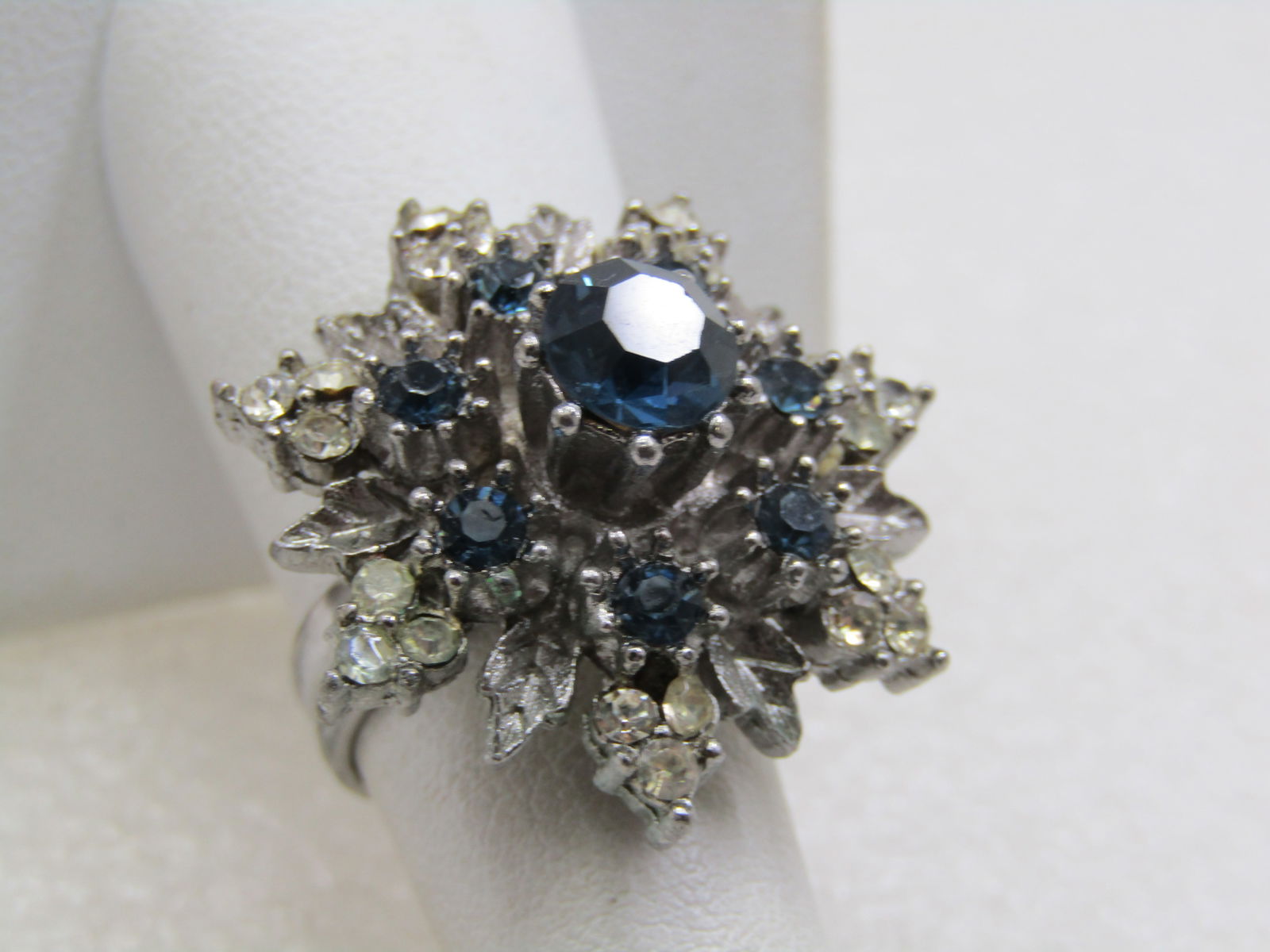Vintage Blue & Clear Rhinestone Blossom/Snowflake Ring, Adjustable, 1950's-1960's: Vintage Blue & Clear Rhinestone Blossom/Snowflake Ring, Adjustable, 1950's-1960's. It is just short of 1.25" across. Tiered design with the bottom level being slightly shorter than the next with textu