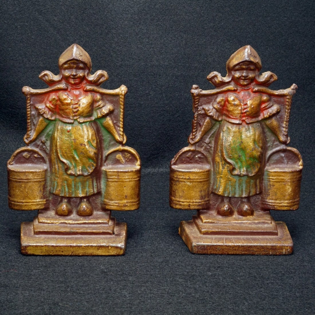 Pair Little Dutch Milkmaid Bookends c 1928: Title:Pair Little Dutch Milkmaid Bookends c 1928 Size:6 ¼ in tall x 4 ¼ in wide x 1 ¾ in deep. Description:A heavy molded pair of very decorative iron bookends and a cold-painted
