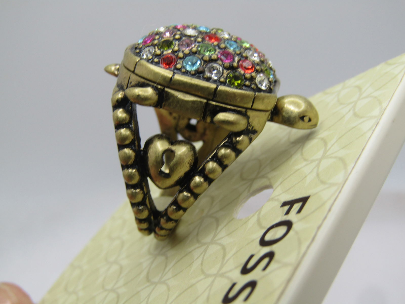 Fossil Rhinestone Turtle Locket Ring , Sz. 7, On Original Card, 1990's: Title: Fossil Rhinestone Turtle Locket Ring , Sz. 7, On Original Card, 1990's Description: Fossil Rhinestone Turtle Locket Ring , Sz. 7, On Original Card, 1990's. Vintage new on card, gold tone turtle