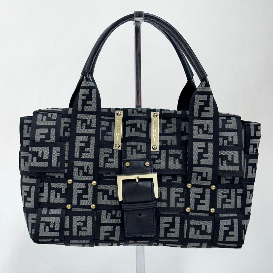 FENDI Baguette handbag in FF fabric with black leather details: Title: FENDI Baguette handbag in FF fabric with black leather details Materials:Canvas Dimensions: • Length: 28 cm• Height: 16 cm• Width: 7 cm Description:(6186B283). Fendi Baguette