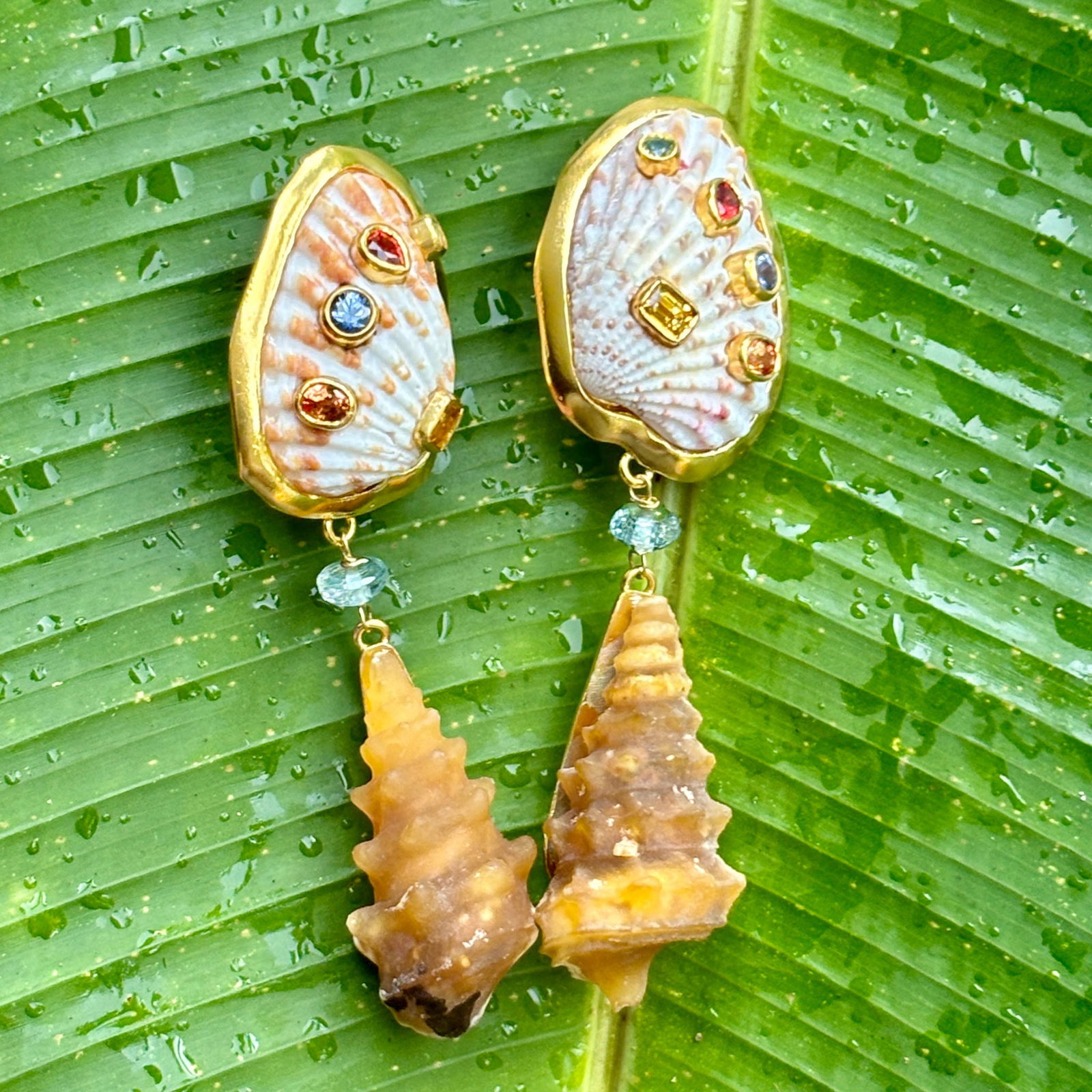 Vermeil, Sapphire and Fossil Earrings.: Title:Vermeil, Sapphire and Fossil Earrings. Description:Unusual pair of Cockle and Fossil earrings. Tops are dotted with colorful Sapphires, faceted Aquamarine beads and drops of rare shell fossils.