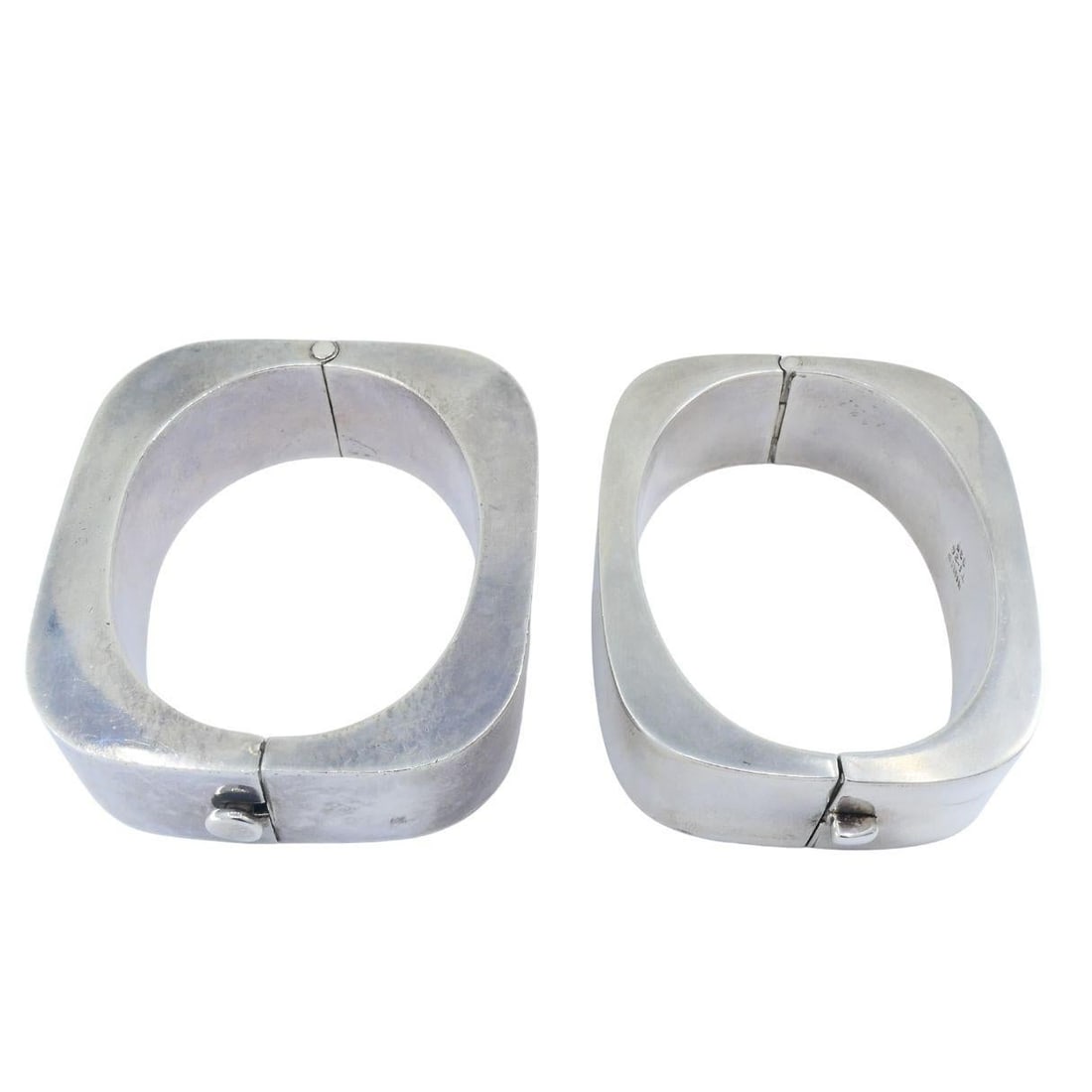 Vintage Sterling Silver Mexico Geometric Hinge Bracelet Pair: Title: Vintage Sterling Silver Mexico Geometric Hinge Bracelet Pair Description: A pair of sterling silver hinged bangles from Mexico, crafted with the bold geometric forms characteristic of late-20th