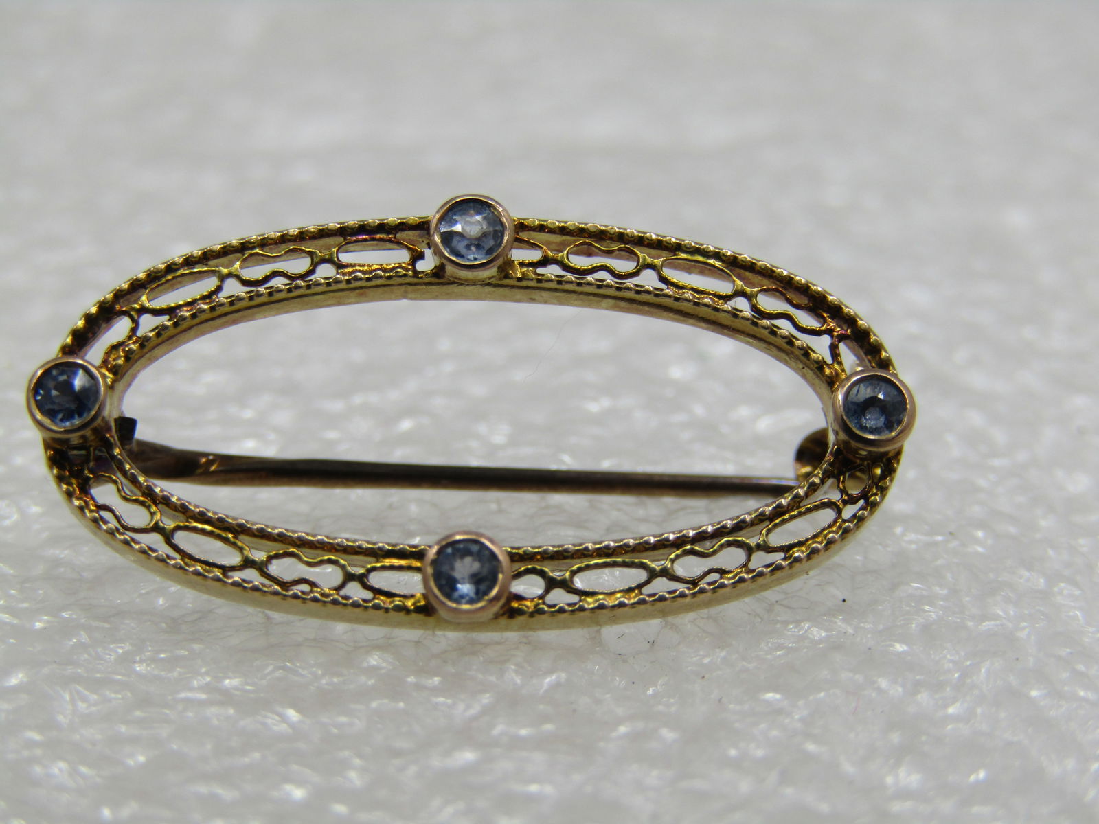 10kt Blue Topaz Victorian/Edwardian Oval Brooch, 1-1/8": 10kt Blue Topaz Victorian/Edwardian Oval Brooch, 1-1/8" wide and slightly over 1/2" tall. Weight is 1.83 gr. It is marked 10kt on the C-clasp htat has a locking lever. The blue topaz are raised on the