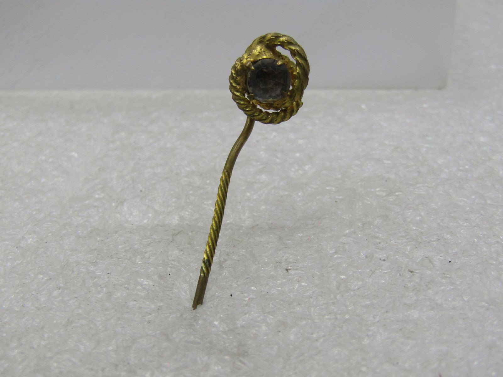 Victorian Love Knot Stick Pin, Glass Stone, 2": Victorian Love Knot Stick Pin, Glass Stone, 2" long with a twisted center to the stick pin and twisted love knot on top with a center old cut rhienstone (clear). The topper is papx. 1/2". Lae 1800's.