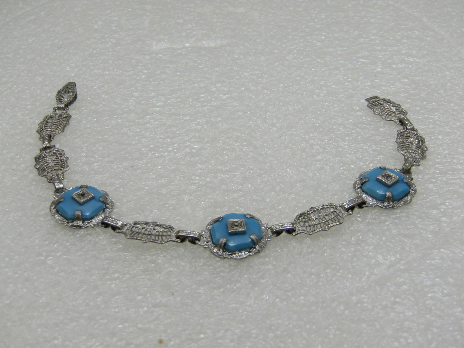 Vintage Art Deco Filigree Turquoise Glass Bracelet, 7", Rhodium Plated: Vintage Art Deco Filigree Turquoise Glass Bracelet, 7", Rhodium Plated. There are three turquoise glass links with a center clear rhinetone set in a miilgraine square on top of the turquoise stone whi