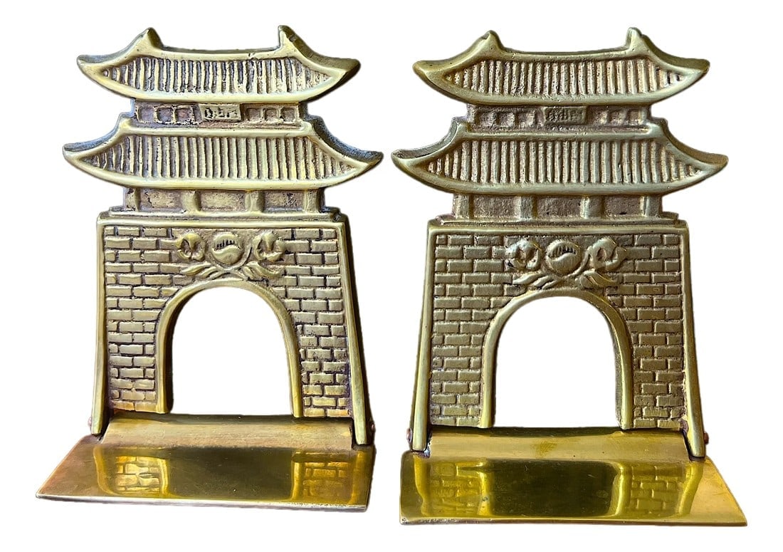Vintage Brass Pagoda Bookends Chinoiserie Asian Revival Style: Handsome pair of vintage solid brass bookends, beautifully cast in the form of traditional multi-tiered pagodas. Each features a brick-textured arched gateway crowned with sweeping tiered roofs, recal