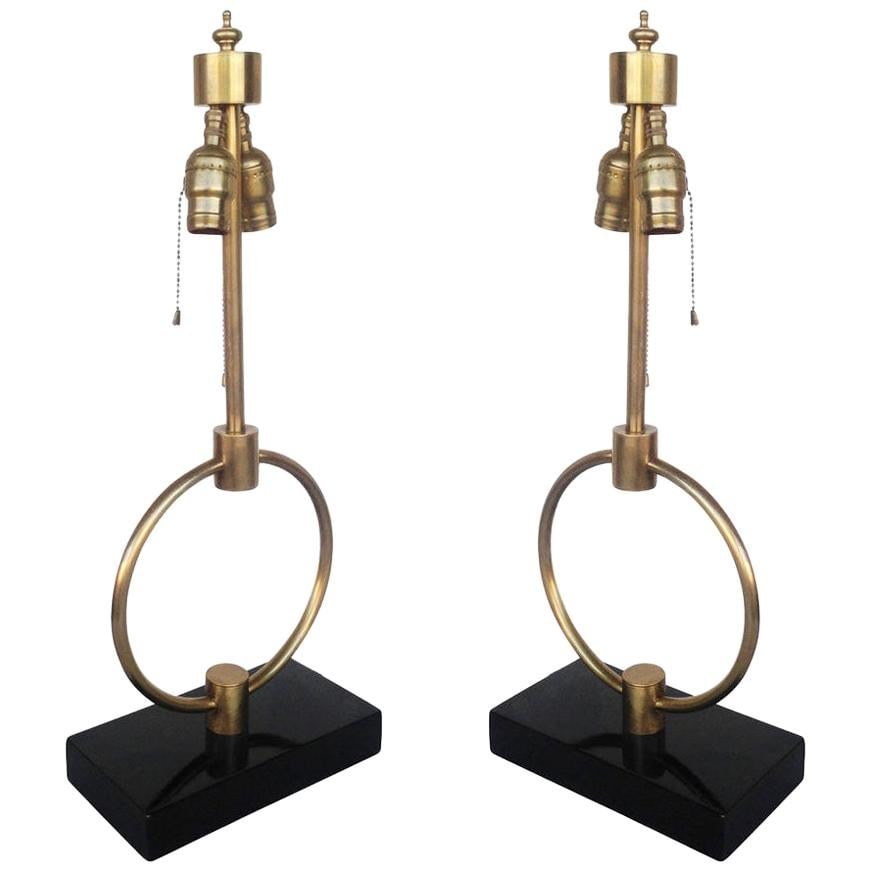 Mid-century Gilbert Rohde Style Brass Ring Table Lamp, Pair: Title: Mid-century Gilbert Rohde Style Brass Ring Table Lamp, Pair Description: Gilbert Rodhe style brass ring table lamp pair featuring a center brass ring fixed to a lacquered wood base. Each lamp h