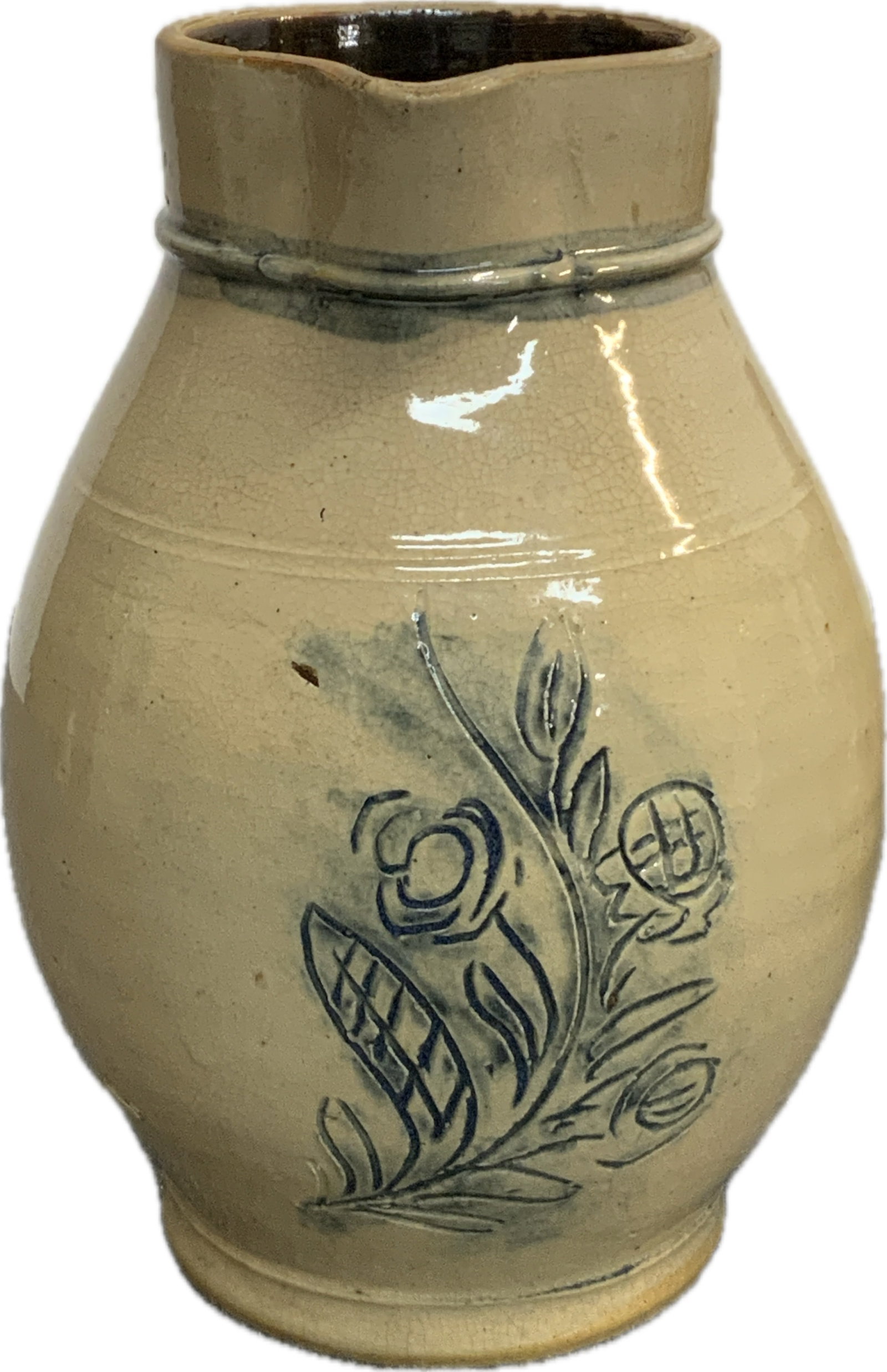 Incised Stoneware Pitcher: 19th C. Decorated Stoneware Pitcher probably Pennsylvania. Handled Pitcher with Incised Cobalt Floral Sprig. Additional Cobalt Highlights to Neck Ring. Small Rim Chip, Glaze Void and Some Crazing. 9&#