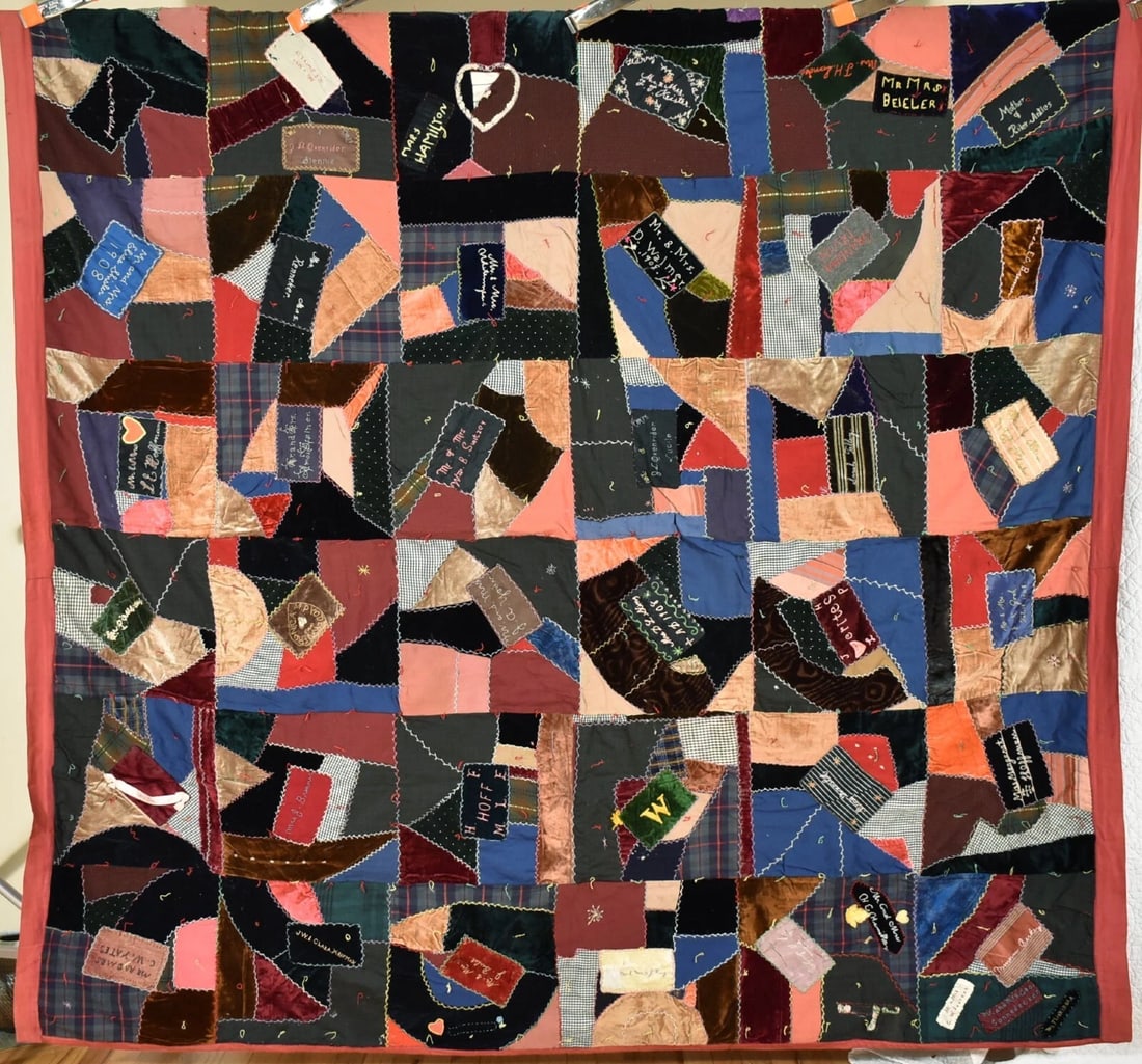 Authentic Amish Crazy Quilt, Dated "1908": This outstanding cotton crazy tied quilt is all hand and treadle machine pieced, with folky hearts and other symbols, multiple Amish names (Shisler, Yoder, e.g.) and the hand embroidered date "1908."
