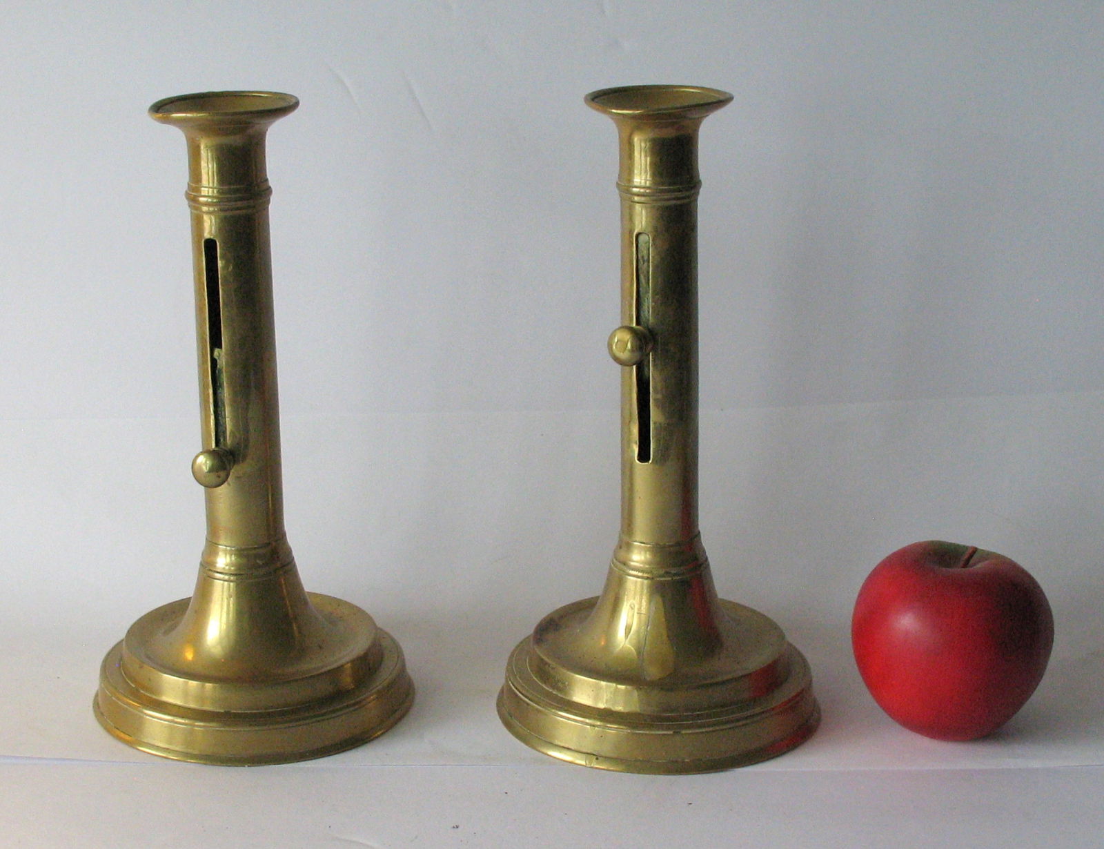 Pair of antique brass New England candle sticks.: Title: Pair of antique brass New England candle sticks. Date/Period: 1900's Dimension: 4 3/4” x 9 1/4” high Additional Information: Nice pair of antique brass New England candle sticks in
