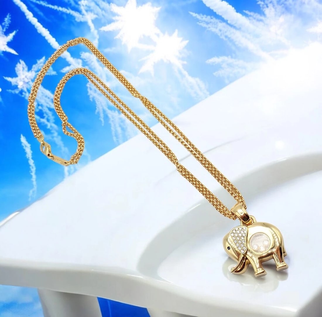 Authentic! Chopard 18k Yellow Gold Large Happy Elephant Pendant Necklace: This exquisite Chopard necklace features a large Happy Elephant pendant and Chopard double chain crafted in 18k yellow gold. Its playful design showcases a transparent belly with 3 floating diamonds,