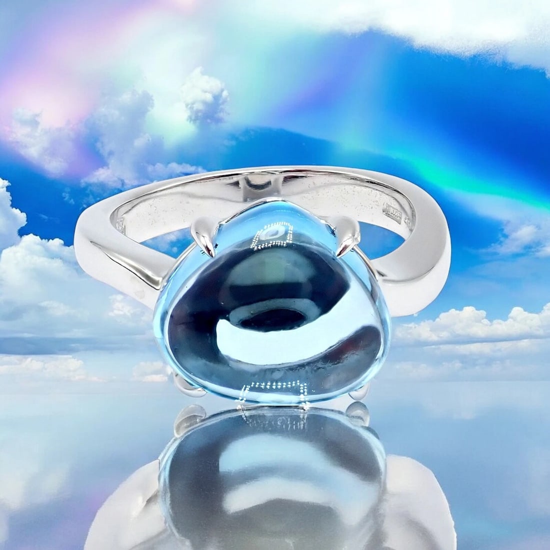 Authentic! Bulgari 18k Whtie Gold Mediterranean Eden Blue Topaz Ring Size 6: This captivating Bulgari Mediterranean Eden ring features a luminous blue topaz cabochon set in polished 18k white gold. Elegant and fluid in design, the ring captures the essence of the sea with its