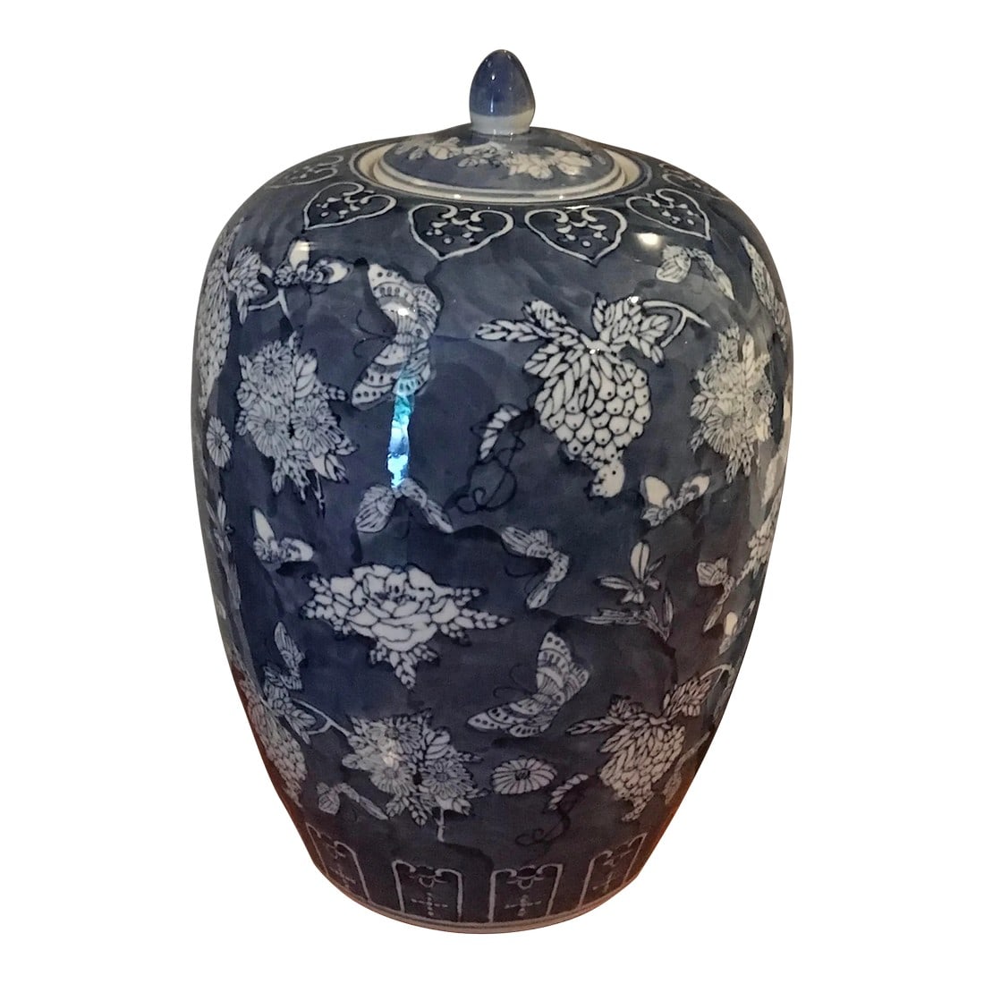 Late 20th Century Blue and White Jar: This elegant ceramic ginger jar features a classic blue and white design, adorned with a charming butterfly and floral motif. Complete with is matching lid, it's a timeless decorative piece that adds