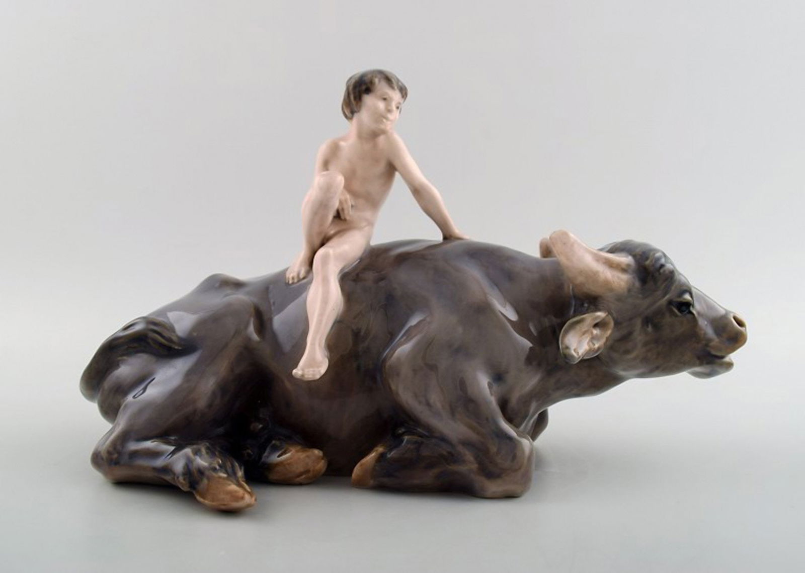Rare Royal Copenhagen figure, naked boy on water buffalo. Model number 1849.: Title: Rare Royal Copenhagen figure, naked boy on water buffalo. Model number 1849. Description: Rare Royal Copenhagen figure, naked boy on water buffalo. Model number 1849. Measures 30 cm. X 18 cm. I