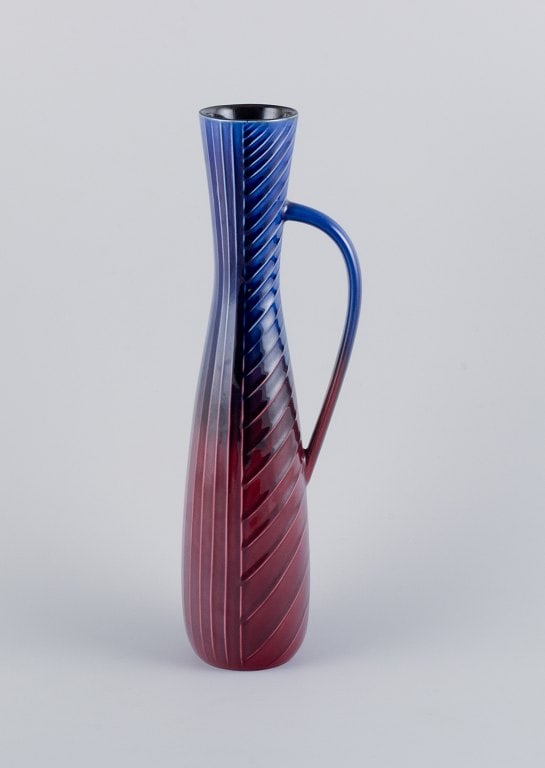 Carl Harry Stålhane for Rörstrand. Tall and slim ceramic pitcher in blue and burgundy: Title: Carl Harry Stålhane for Rörstrand. Tall and slim ceramic pitcher in blue and burgundy tones. Description: Carl Harry Stålhane for Rörstrand. Tall and slim ceramic pitcher in