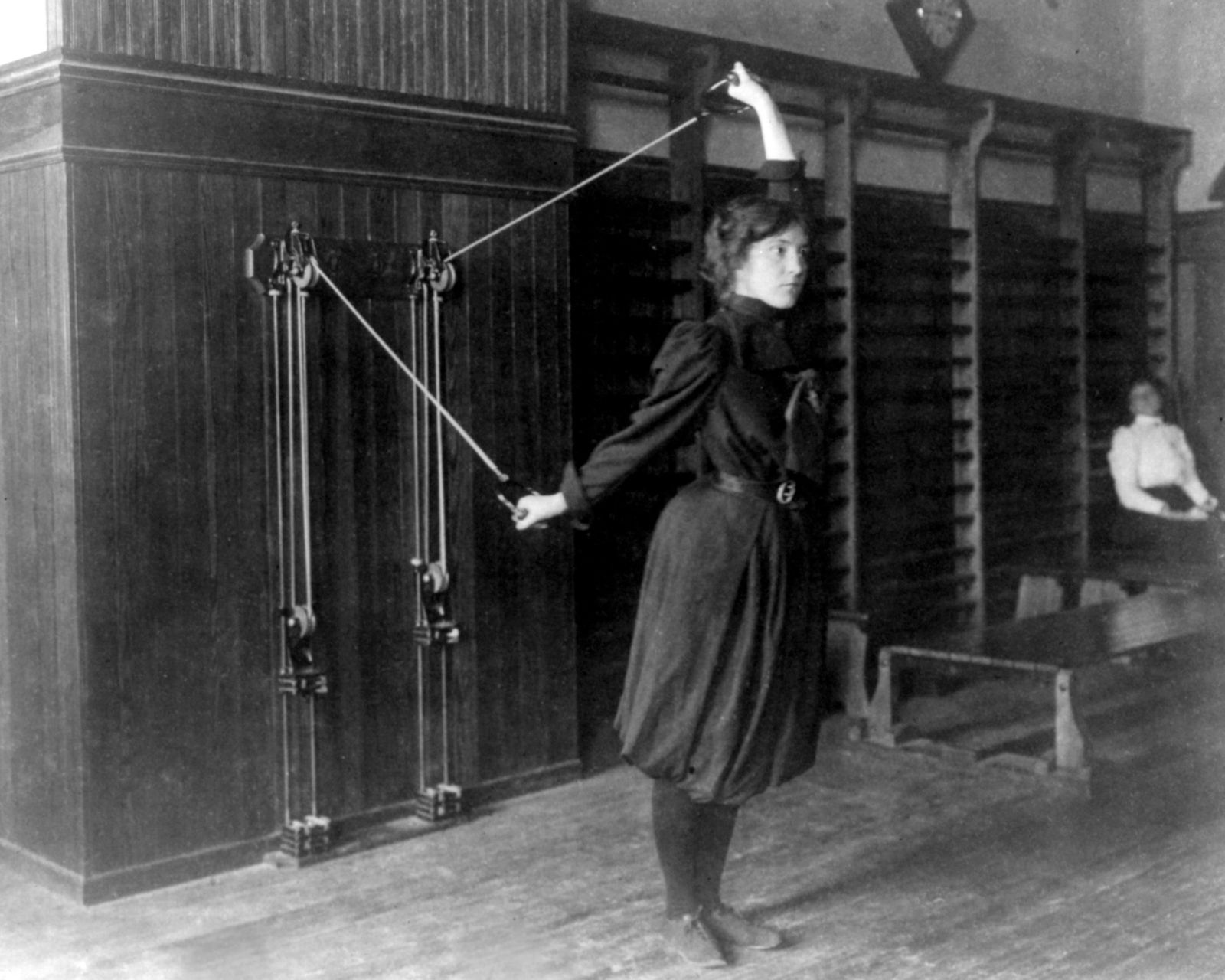 1897, Woman Exercising With Wall Mounted Ropes And Pulleys: Title: 1897, Woman Exercising With Wall Mounted Ropes And Pulleys Artist/Source: Frances Benjamin Johnston Original Date: 1897 Dimensions: 8X10 Description: || UNITED STATES SHIPPING ONLY! || This lot