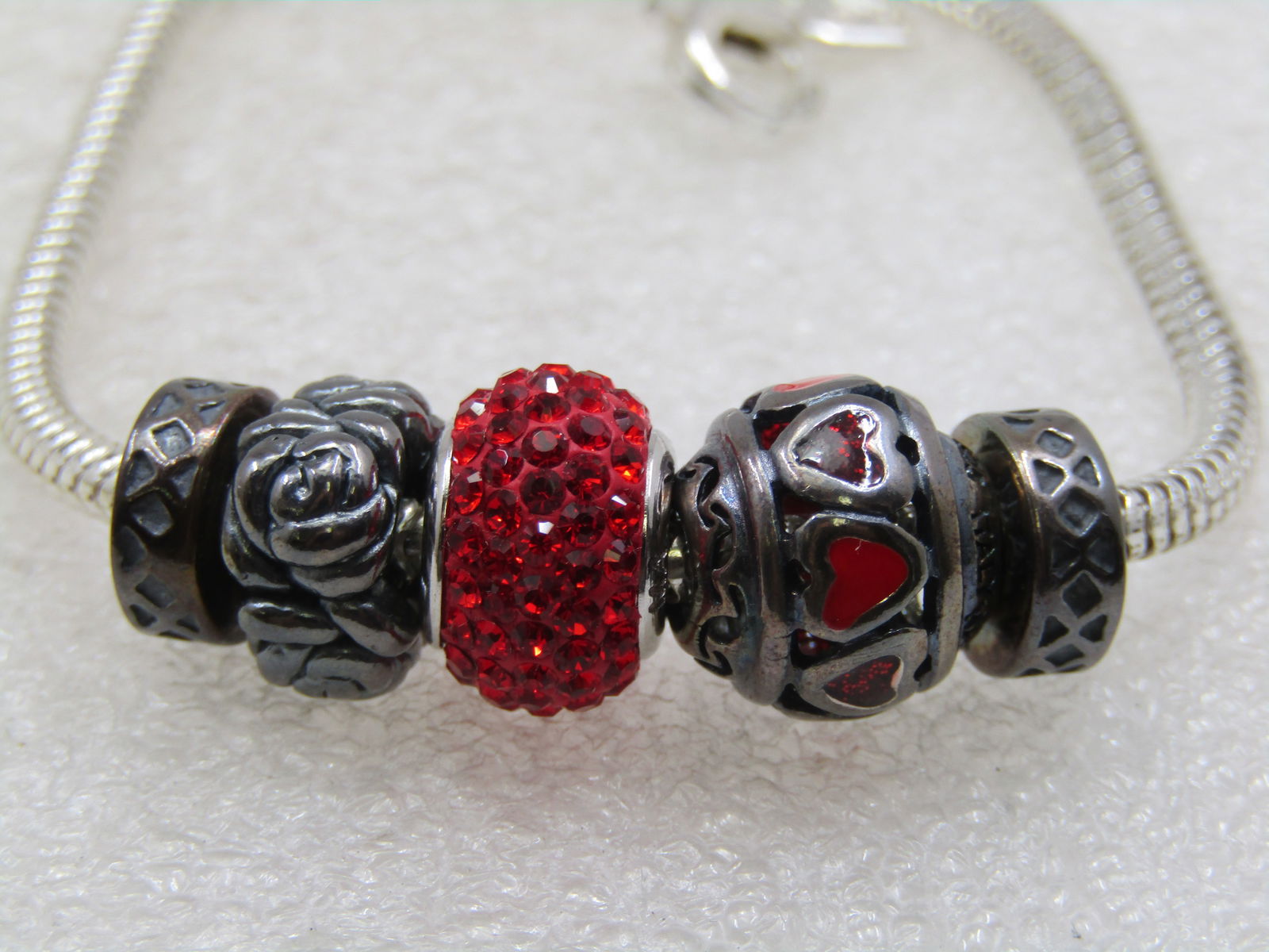 Sterling Silver Rhinestone Slide Charm Bracelet, Kay Jeweler's, Signed MA, 8": Sterling Silver Rhinestone Slide Charm Bracelet, Kay Jeweler's, Signed MA, 8" with 5 slides - a red rhinestone in the center and a red enameled and rhinestone heart, rose beaded and an end stamped X (