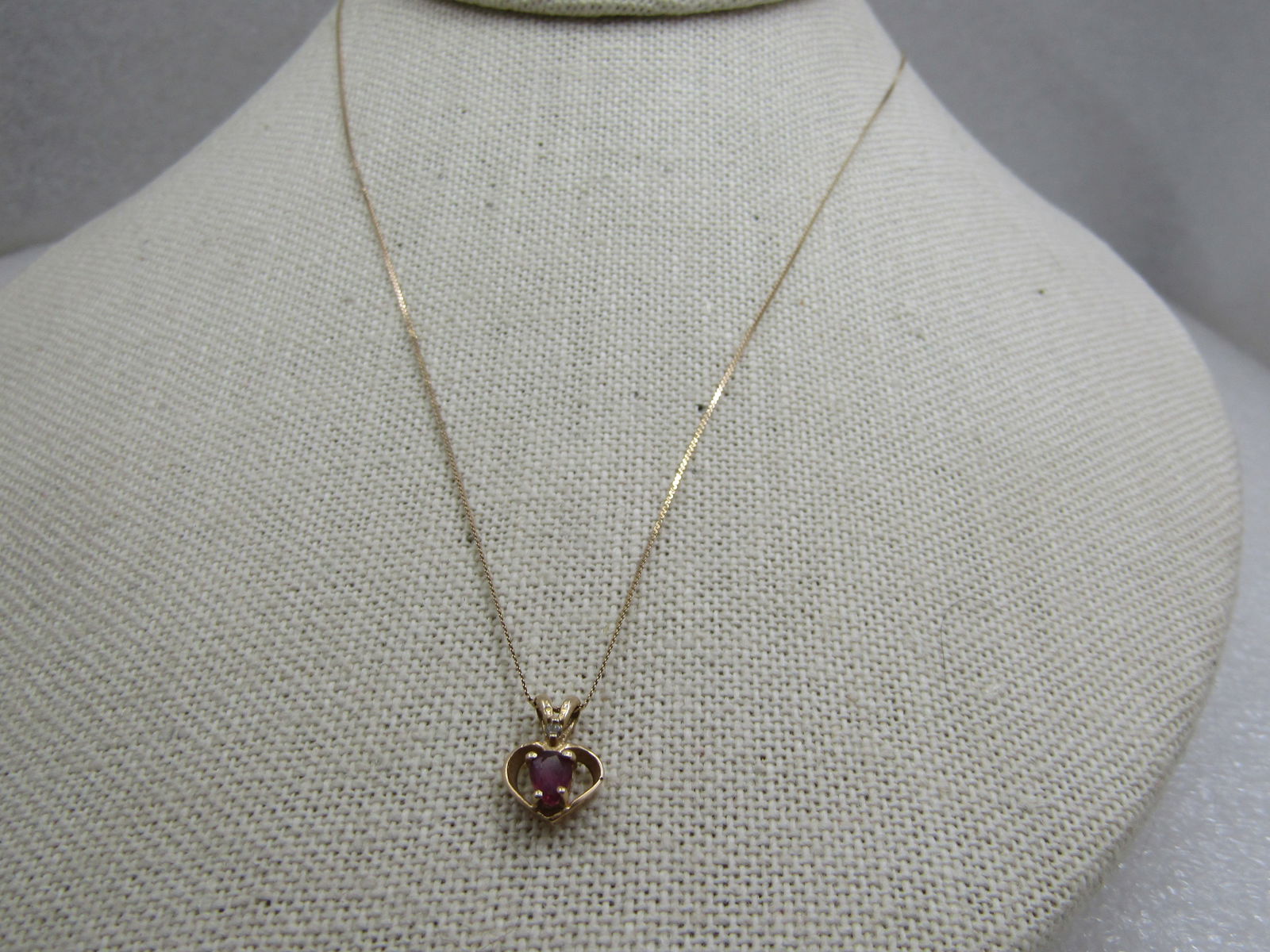 Vintage 14kt Ruby Diamond Heart Necklace, 19": Vintage 14kt Ruby Diamond Heart Necklace, 19", yellow gold open hart with a center oval ruby that is appx. 3.8mm by 3.2mm and a small diamond chip in the base of the split bail on top. The pendant is