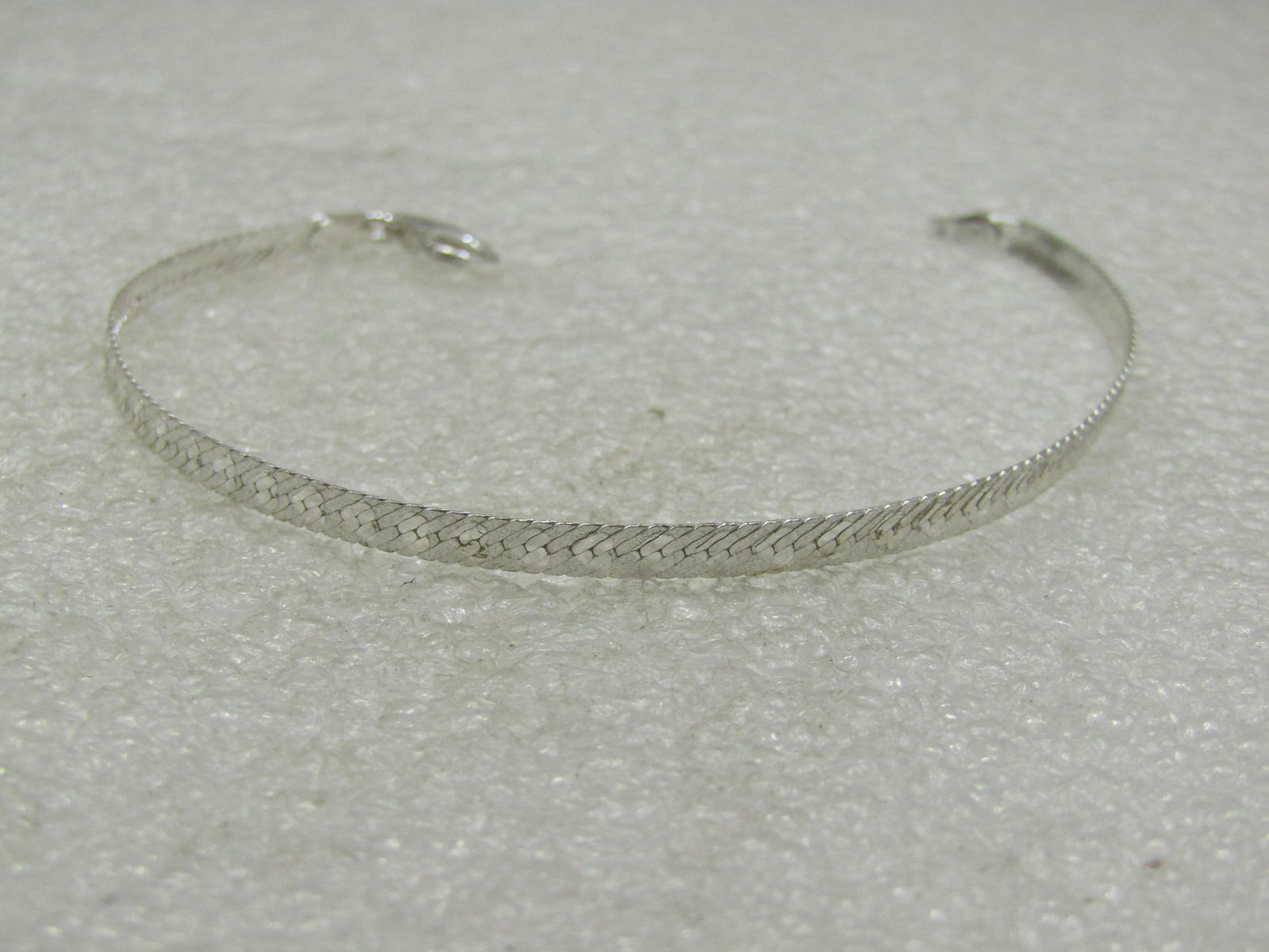 Sterling Silver Heart Herringbone Bracelet, 7": Sterling Silver Heart Herringbone Bracelet, 7" and appx. 2.93 grams. It is appx. 3.2mm wide with a textured background and shiny hearts on the entire length of the bracelet. Lobster clasp. It is signe