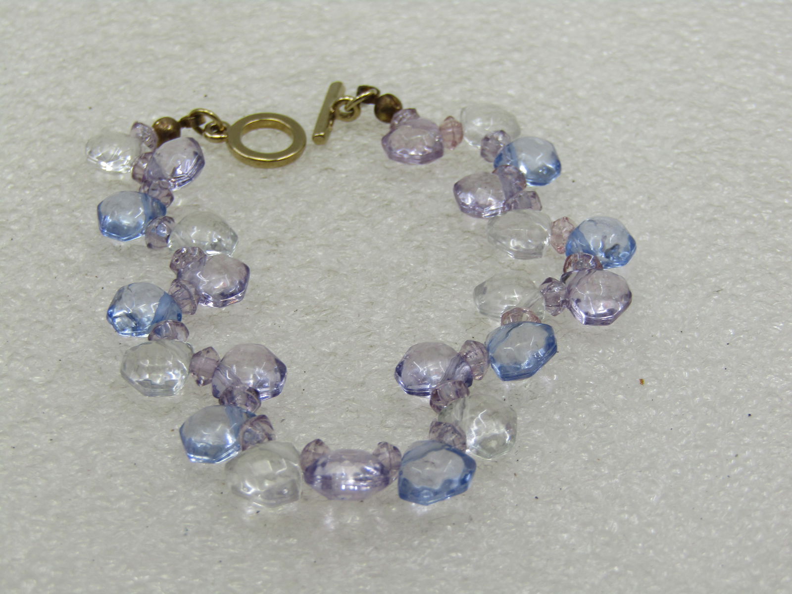 Early 1900's Heart Locket Necklace, 20" 12kt G.F.: Liz Claiborne Lavender/Blue Crystal Bracelet, 7" Toggle Clasp. The faceted beads are on both sides of the cord creating a wavy look and they look blue, lavender, and clear. Triangular faceted beads, a