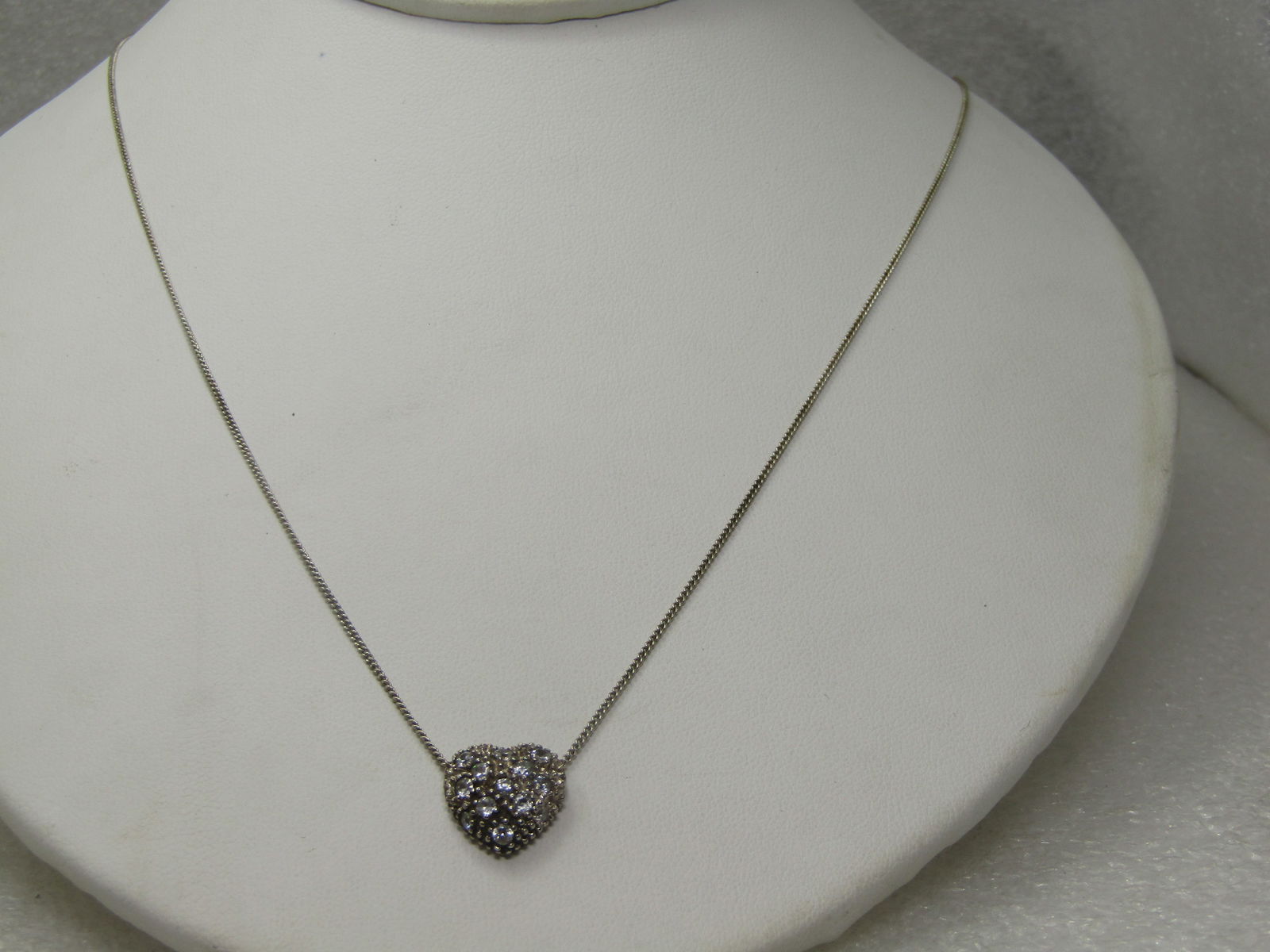 Sterling Silver Pave Set Heart Necklace, 18", Signed Avon: Sterling Silver Pave Set Heart Necklace, 18", Signed Avon. Marked sterling, tested with a weight of appx. 3.10 gr. The heart is aoox, 1/2" wide and tall domed with pave set clear stones. The chain is