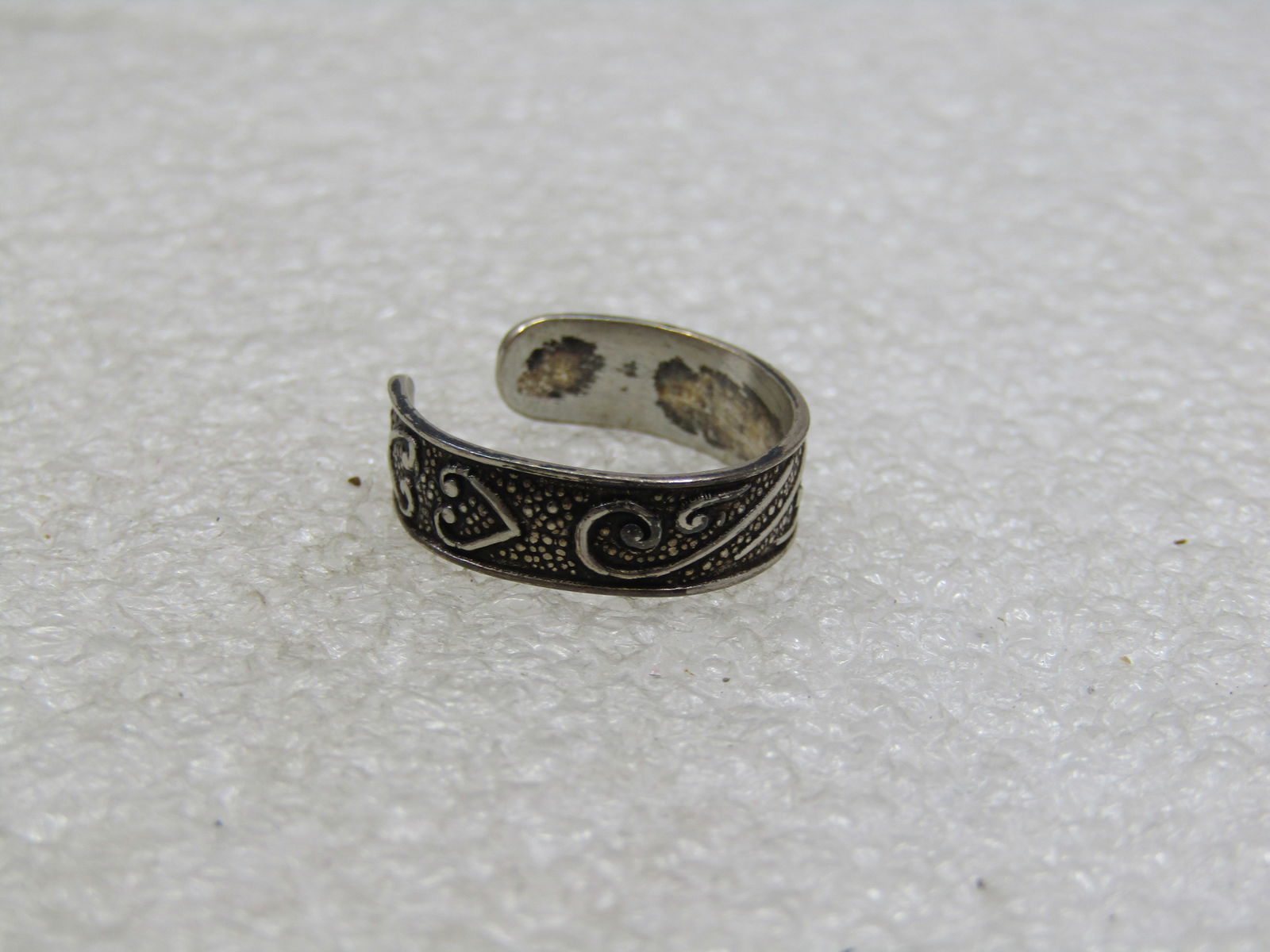 Vintage Sterling Silver Scrolled Heart Toe Ring, Adj.: Vintage Sterling Silver Scrolled Heart Toe Ring, Adj. 5mm wide at top center and tapers to appx. 4.5mm at the back, open back for adjusting. Marked .925 and tested, weight is appx. 1.46 grams. Texture