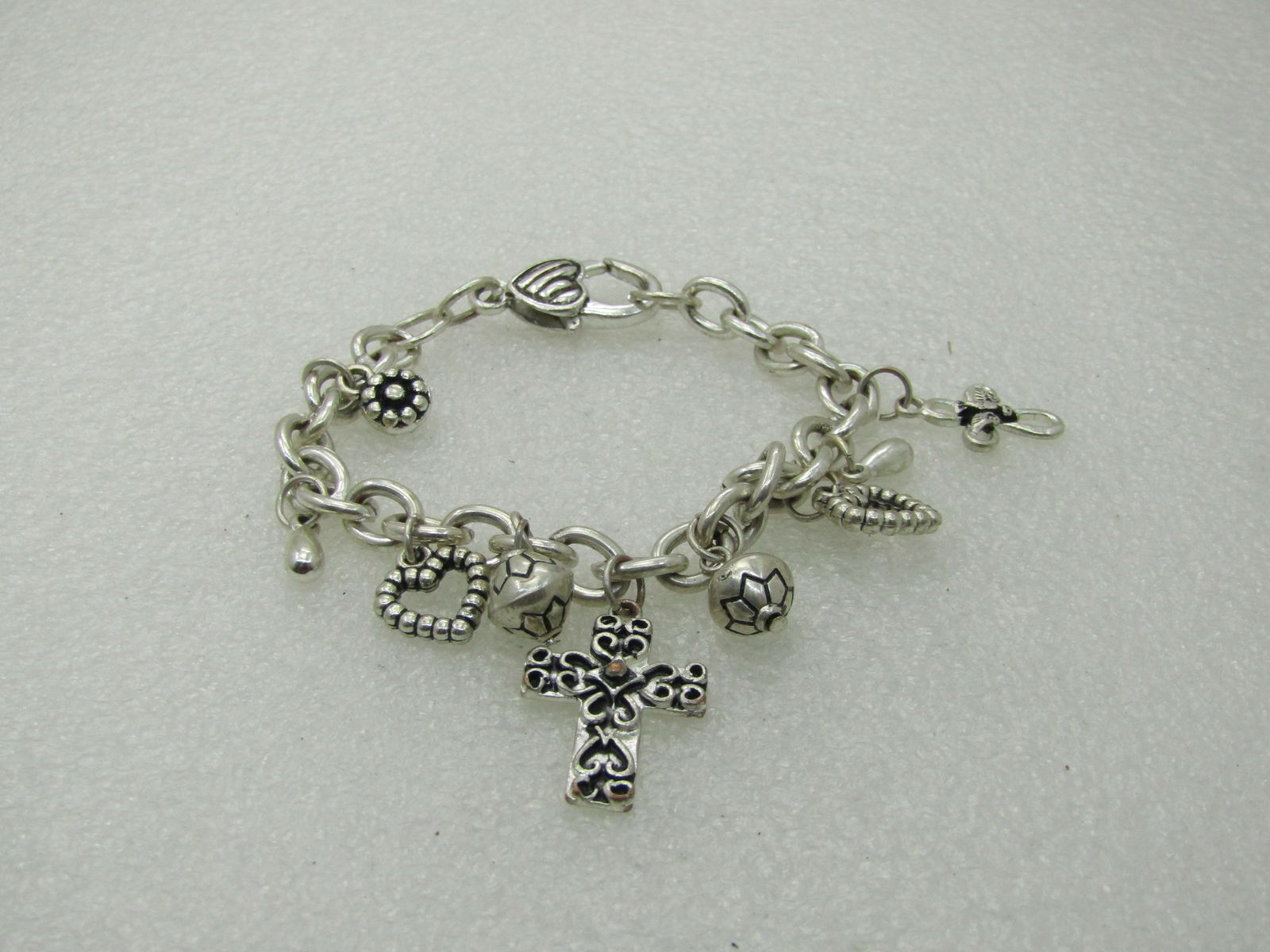 Vintage Silver Tone Christian Charm Bracelet, 7": Vintage Silver Tone Christian Charm Bracelet, 7", Longest drop is 1.25" and is the two-tone cross at center with scrolled accents, miscelaneous beads, heart charms and cross with dove. Oversized heart