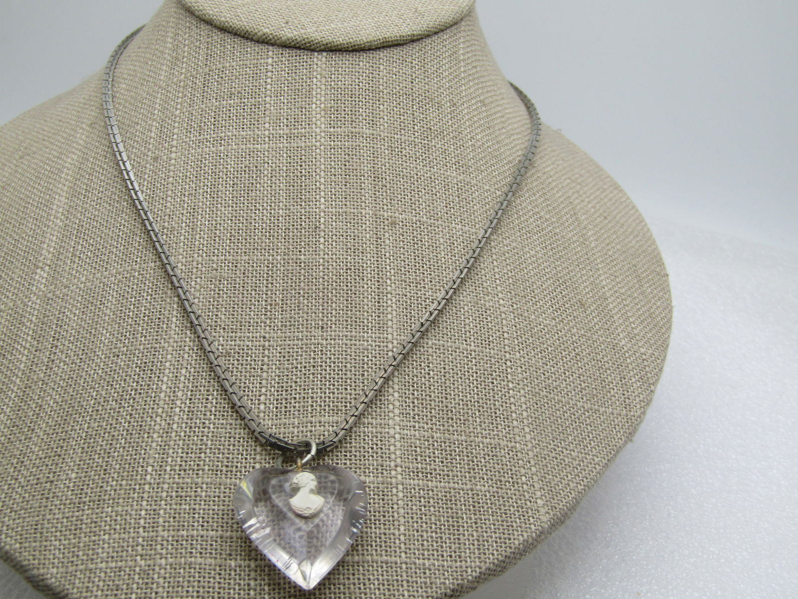 Vintage Clear Heart Cameo Necklace, 17.5", 1960's: Vintage Clear Heart Cameo Necklace, 17.5", 1960's. This has a lucite clear heart pendant with a white molded cameo on the short table seton top. The heart with jump ring is 1.25" tall and 1" wide. It