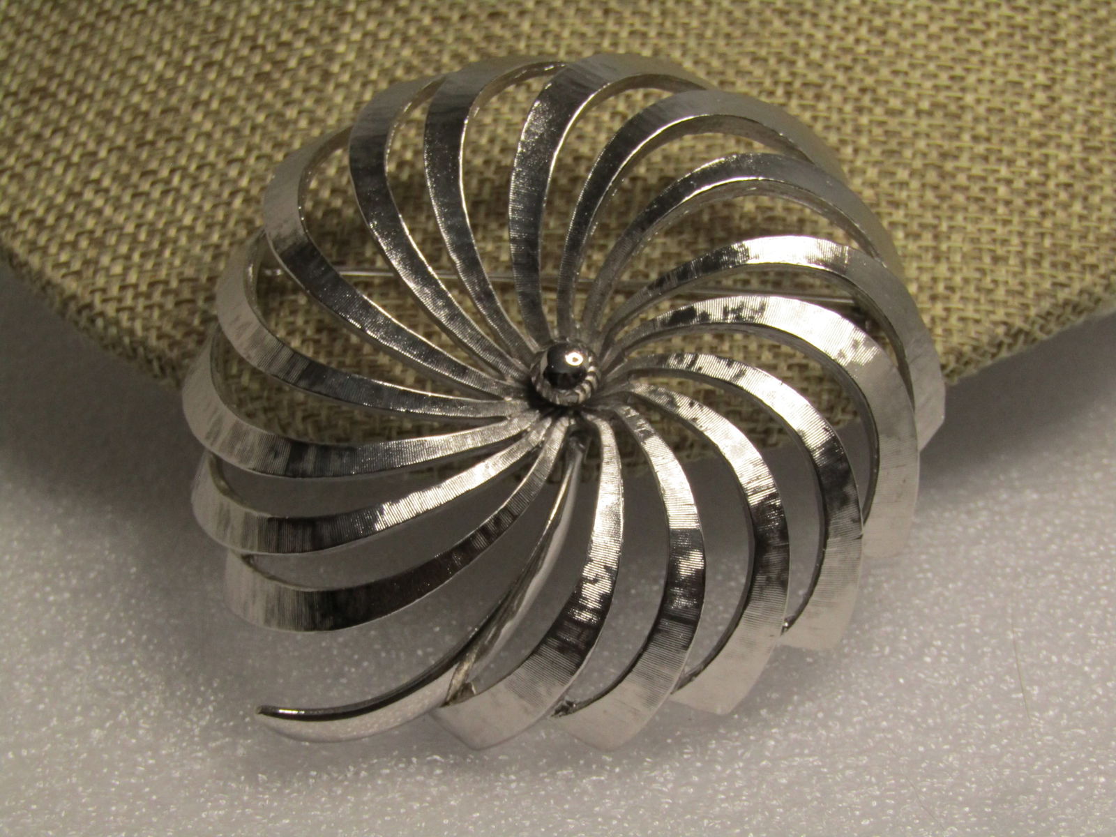 Vintage Monet Spiral Blossom Brooch, Domed, 1970's-1980's: Vintage Monet Spiral Blossom Brooch, Domed, 1970's-1980's. Silver tone with a smooth stem and beaded center and slighted textured sprial petals. It is appx. 2.5" across. Very clean and in very good co