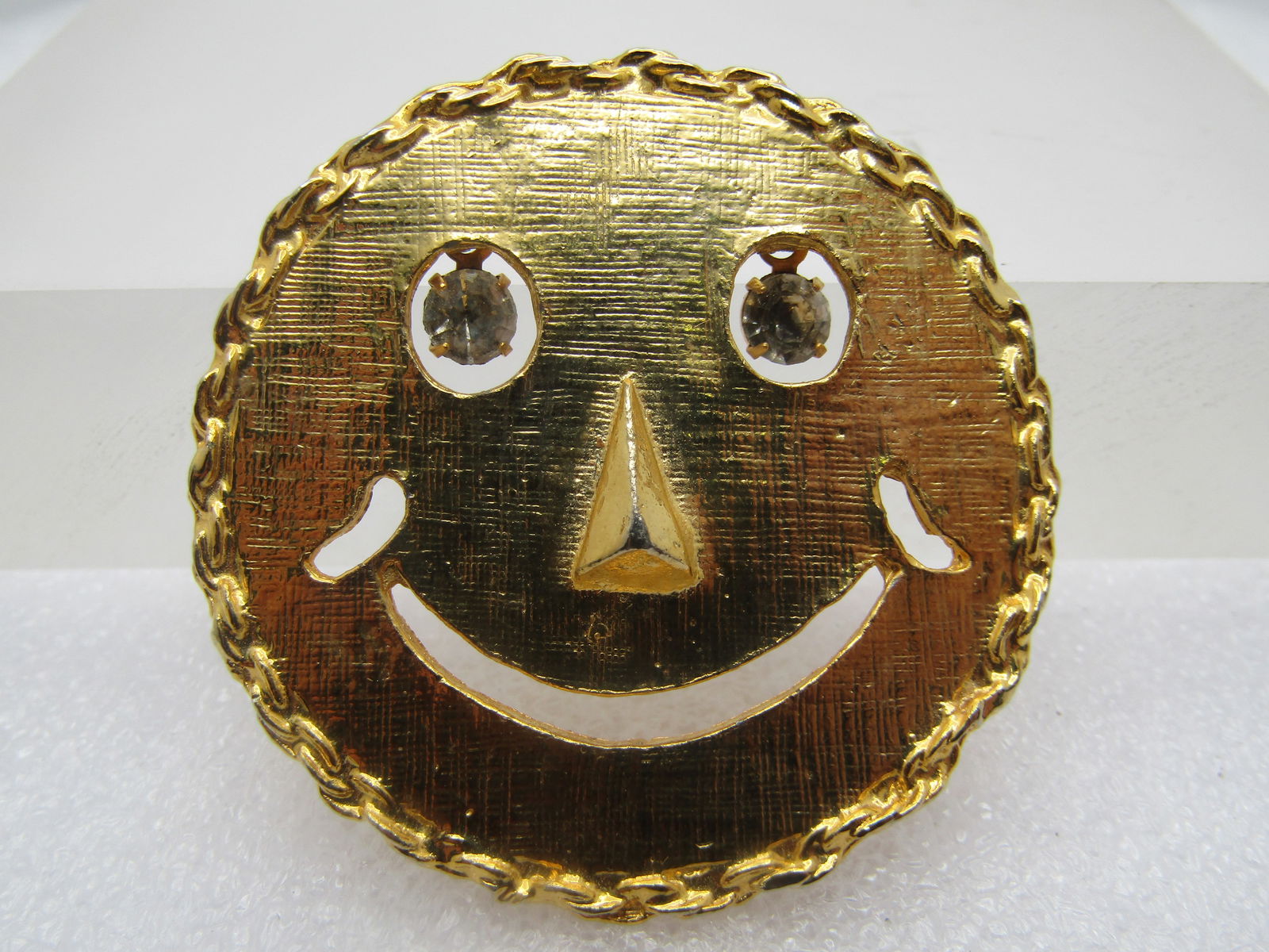 Vintage Smily Face Brooch/Pendant, Rhinestone Eyes, 1970's, Iconic: Vintage Smily Face Brooch/Pendant, Rhinestone Eyes, 1970's. Icon smily face from back-in-the-day. Textured finish with cut-out eyes in which rhinestones dange for the eyes, cut-out mouth and raised no