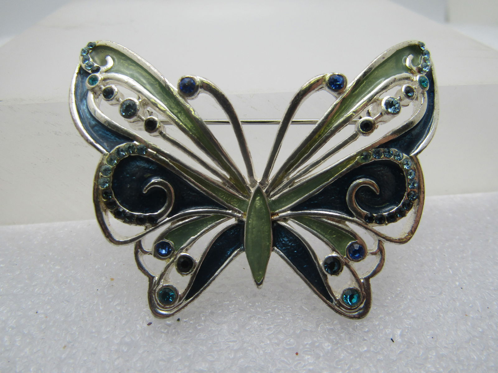 Pair Liz Claiborne Butterfly Brooches, Enameled/Rhinetone, 1990's: Pair Liz Claiborne Butterfly Brooches, Enameled/Rhinetone, 1990's. Blue and green enameled with recessed and raised areas, scrolled, open work, and purple, blue, aqua rhinestones. They are apx. 2.25"