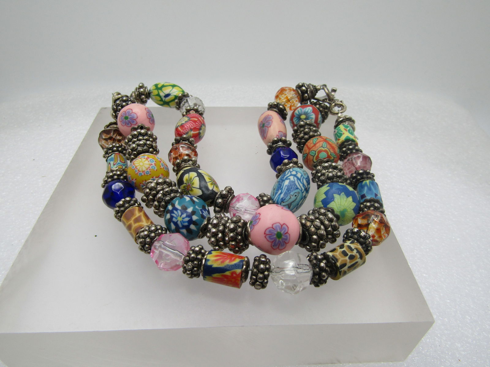 Vintage Sterling Triple Strand Floral, Glass, Crystal Beaded Bracelet, 8": Vintage Sterling Triple Strand Floral, Glass, Crystal Beaded Bracelet, 8". The beads have the loock of Murano floral beads- they are made from a heavy plastic or resin and are a mix of tubular, oval a