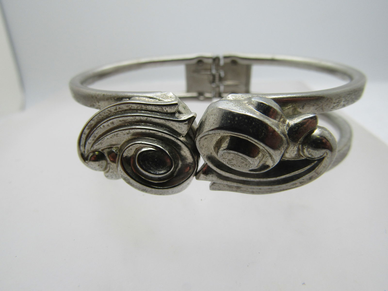 Vintage Hinged Clamper Bracelet, 6.75" Scrolled Accents, 1960's-1970: Vintage hinged Clamper Bracelet, 6.75" Scrolled Accents, 1960's-1970's. It has a scrolled accents that is appx. 3/4" on the top of the bracelet on each side where it meets. It is a tiered design. The