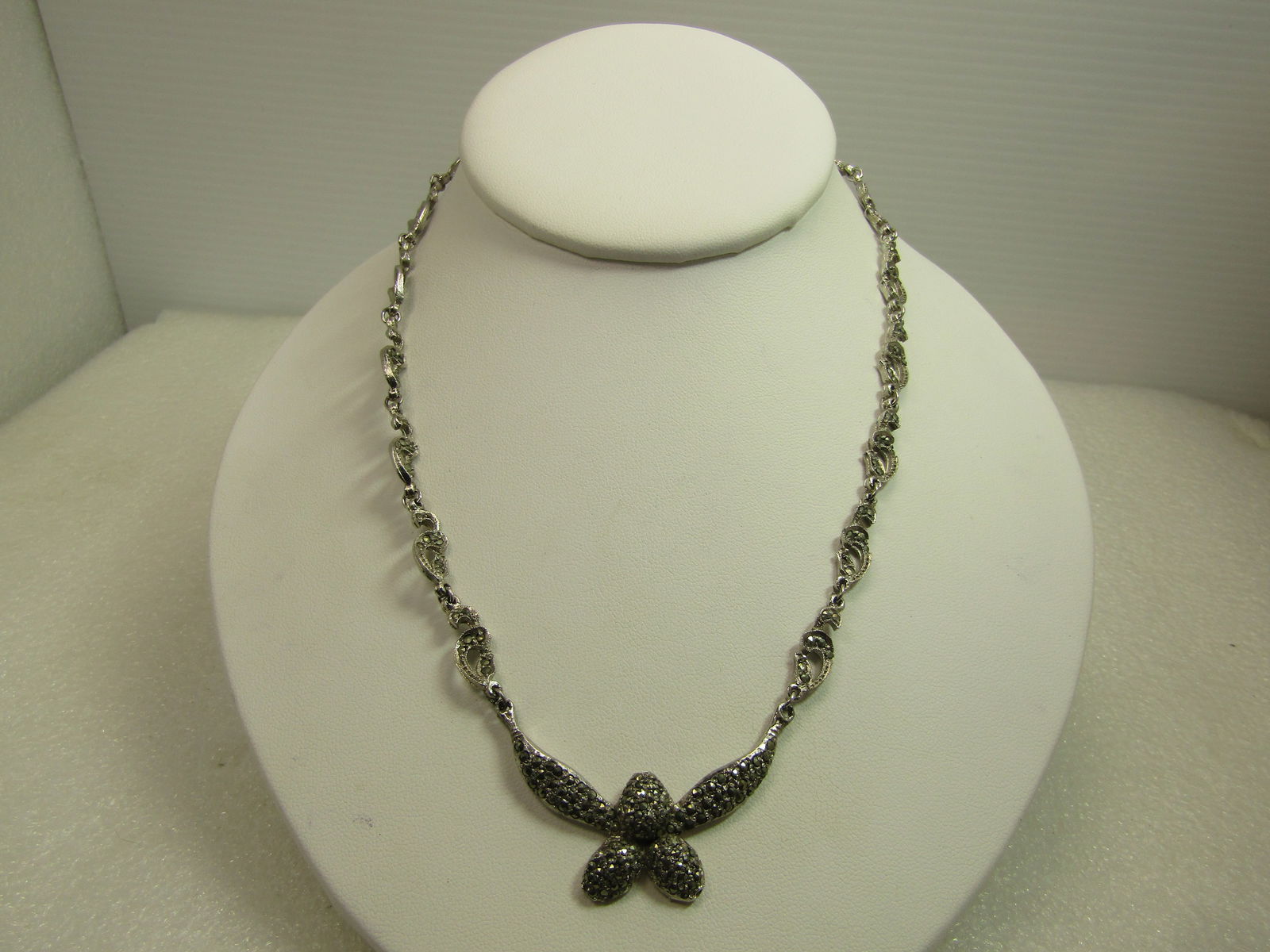 Vintage Faux Marcasite Drop Necklace, 16", 1970's: Vintage Faux Marcasite Drop Necklace, 16", 1970's. Silver tone with curved open links that have marcasite like stones built into the links as well as on the floral-like drop at the front. This has a v