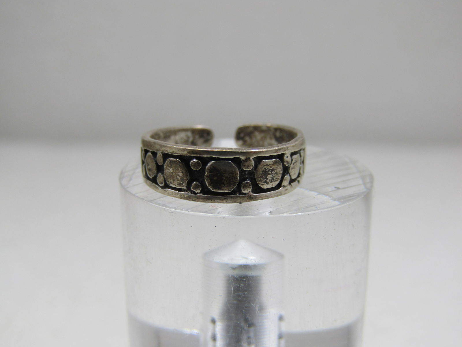 Vintage Sterling Silver Toe Ring, Adjustable, 4.5mm, Signed: Vintage Sterling Silver Toe Ring, Adjustable, 4.5mmm Signed with $ maker's mark. The ring has a raised circle design aross the top of the ring tapers down to 3mm at the back of the finger. It has been