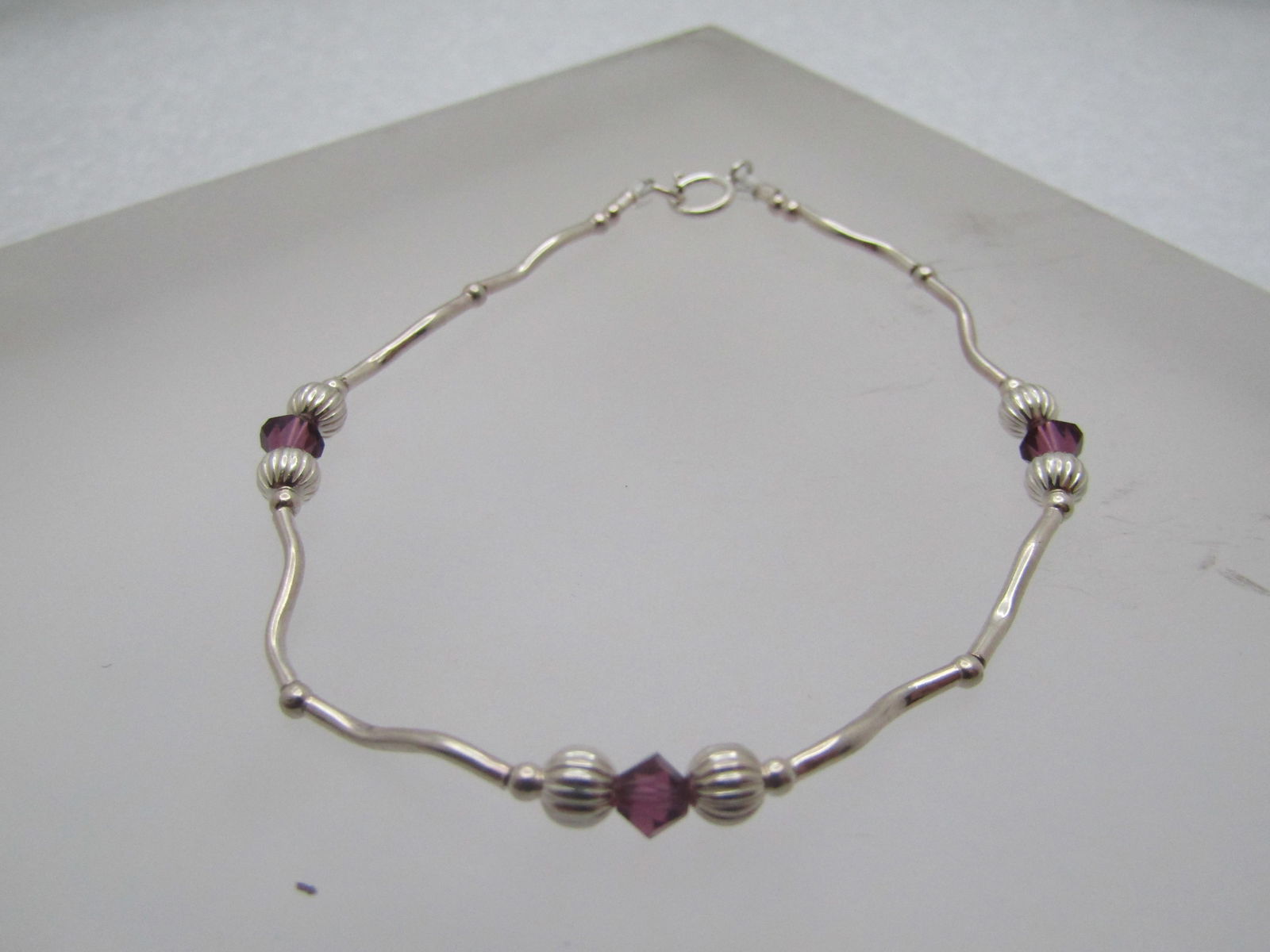 Sterling & Purple Crystal Beaded Bracelet, 7", 1990's-2000's: Sterling & Purple Crystal Beaded Bracelet, 7", 1990's-2000's. This has curved straw sterling beads with small 1.25 round beads and two 3.5mm ridged rounded beads on ech side of a 3.5mm purple crystal