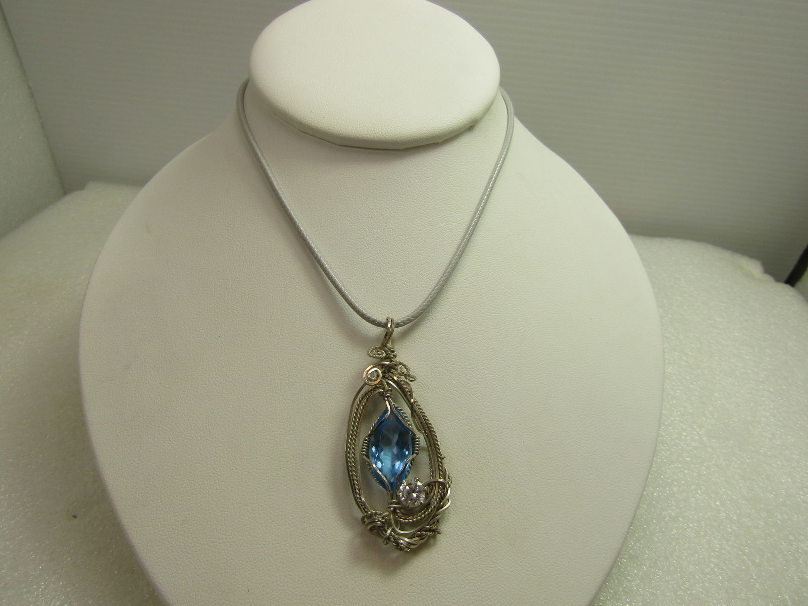 Sterling Wrapped Blue Topaz Necklace, Hand Made, 18"-20", 1990's: Sterling Wrapped Blue Topaz Necklace, Hand Made, 18"-20", 1990's. This has a blue marquise stone that tests and topaz and is appx. 20mm by 10mm and set in the center of a multi-strand sterling wrapped