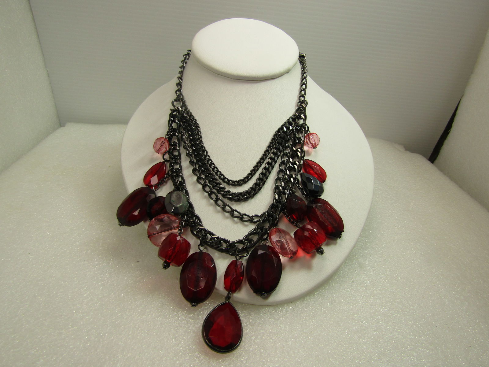 Red/Pink Triple Strand Drop Necklace, 19"-20", 1980's-1990's: Red/Pink Four Strand Strand Drop Necklace, 19"-20", 1980's-1990's. These are clear acrylic beads in round, oval, barrel shaped and one with a black metal bezel around the sides of the tear-drop bead a
