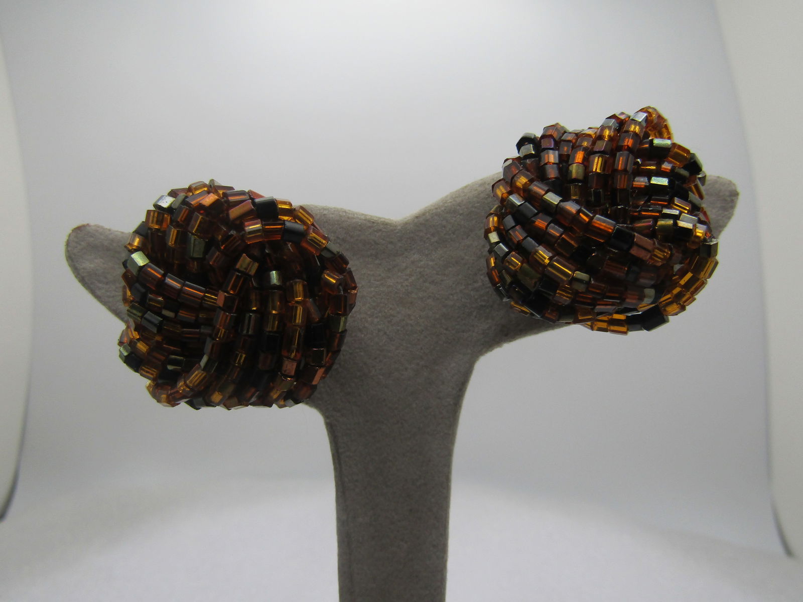 Vintage Black & Amber Brown Beaded Earrings, Clip, 1960's-1980's: Vintage Black & Amber Brown Beaded Earrings, Clip, 1960's-1980's. The seed beads are glas and the brown color is a coppery amber with less black spaced throughout. Arranged in a wrapped multi-strand n