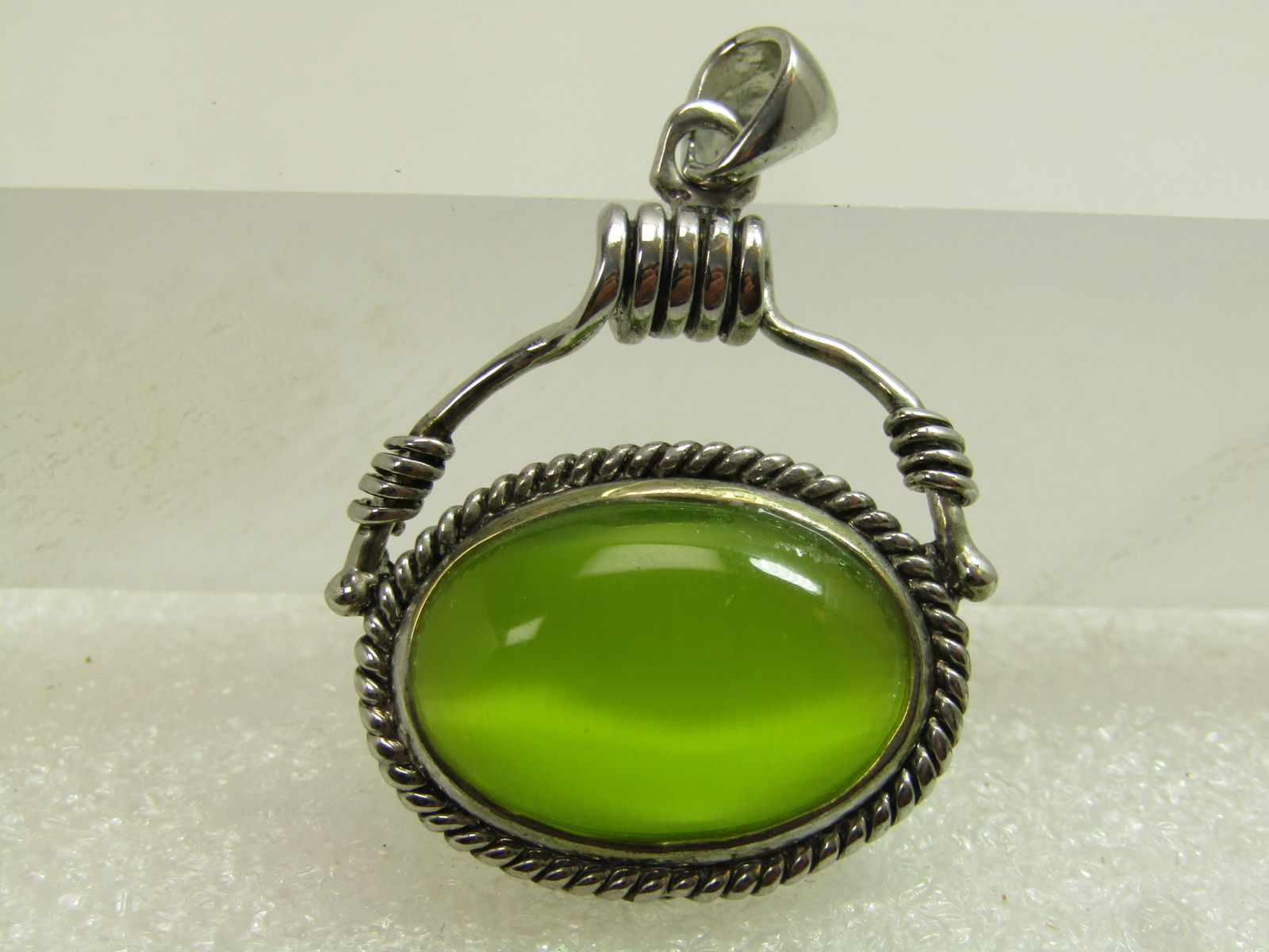 Vintage Faux Green Cateye Pendant, Southwestern Vibe, 1990's: Vintage Faux Green Cateye Pendant, Southwestern Vibe, 1990's. Silver tone. This is a bright and shiny green faux cateye stone, oval that is appx. 22.5mm by 17.5mm with a bezel and rope accent that is