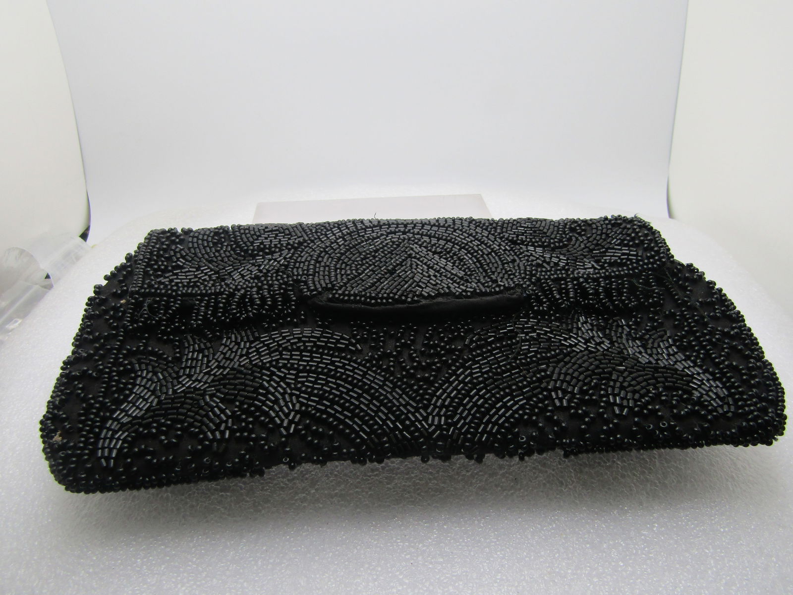 Vintage Wolborg Black Beaded Clutch Purse, 1950's-1960's: Vintage Wolborg Black Beaded Clutch Purse, 1950's-1960's. Fringed on the flat to the left and right of cener. It is appx. 8" by 4" with black fabric lining with a pocket. Signed with the Made in W. Ge