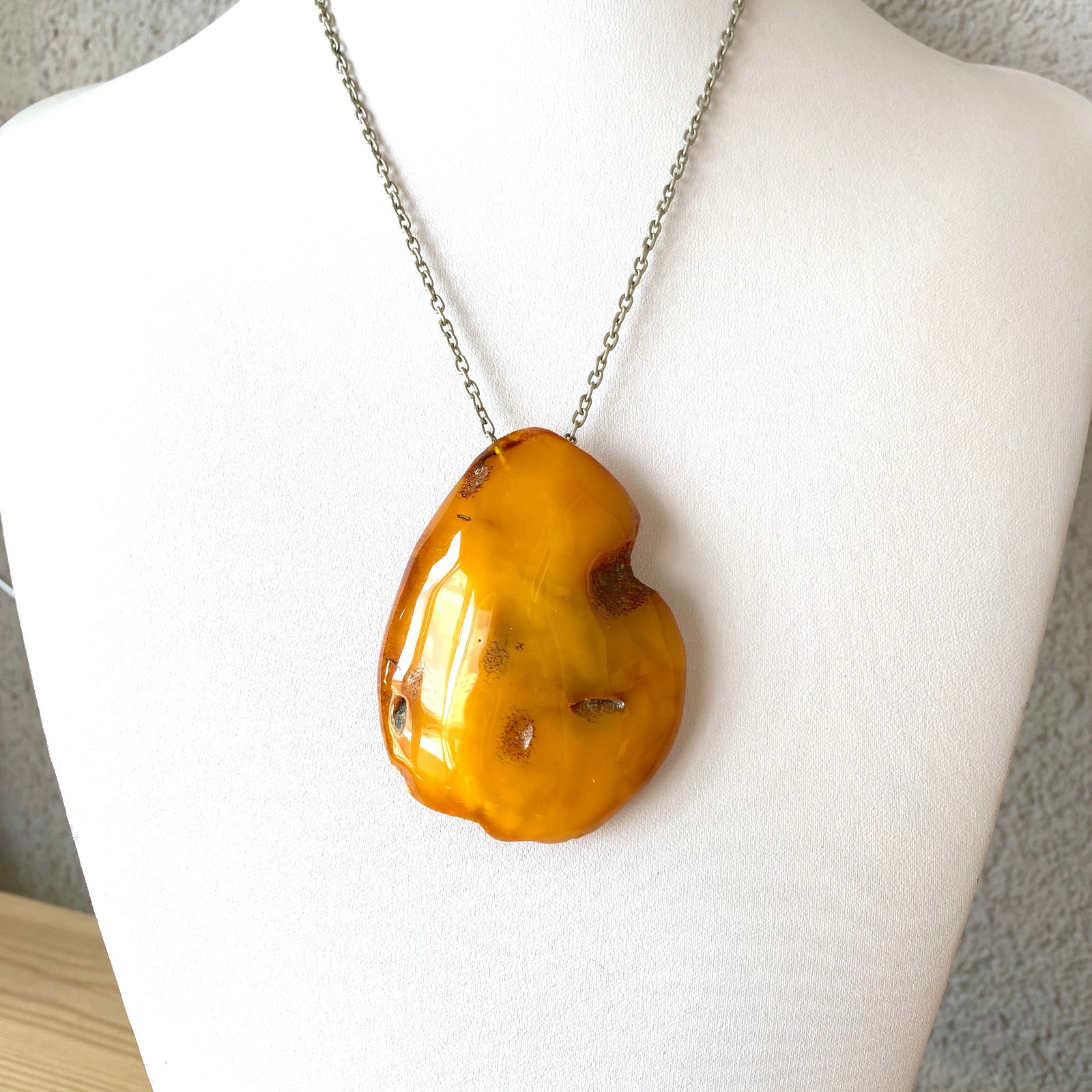 Impressive Vintage Amber Pendant with chain, shaped like a Drop: Title:Impressive Vintage Amber Pendant with chain, shaped like a DropMetal:NoneGemstone:AmberWeight:35.1 gSize:Size: 69.0 x 51.0 x 17.0 mm Made of:(Reconstituted Amber or Whole Stone): Additional