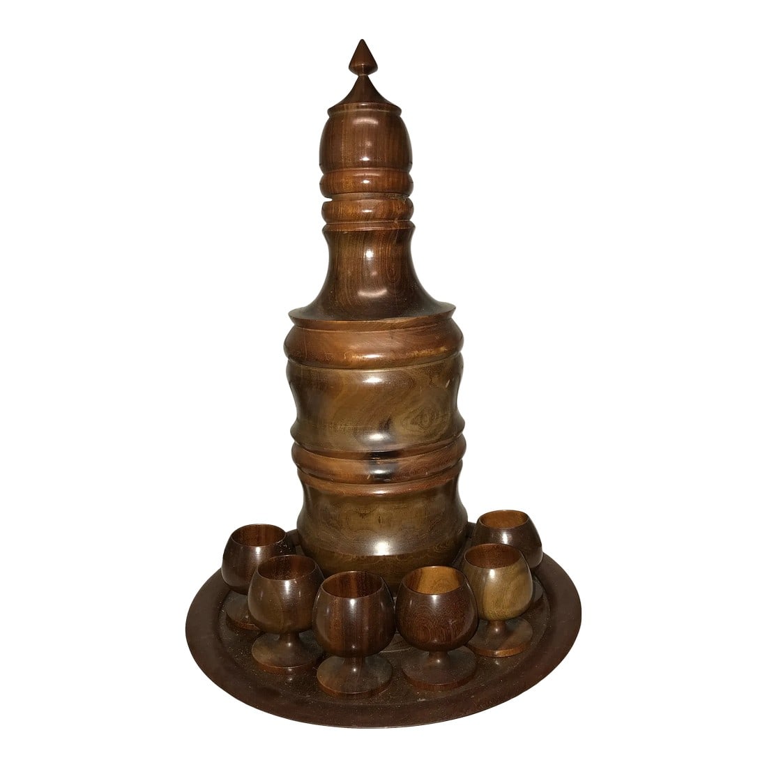 1960s Wood Decanter & Glasses Set- 8 Pieces: Beautiful dark wood liquor set -6 small stemmed cups - a tray and the decanter that separates to hold a bottle of liquor. Up to 3" in diameter. The marking in they center of the tray states that this
